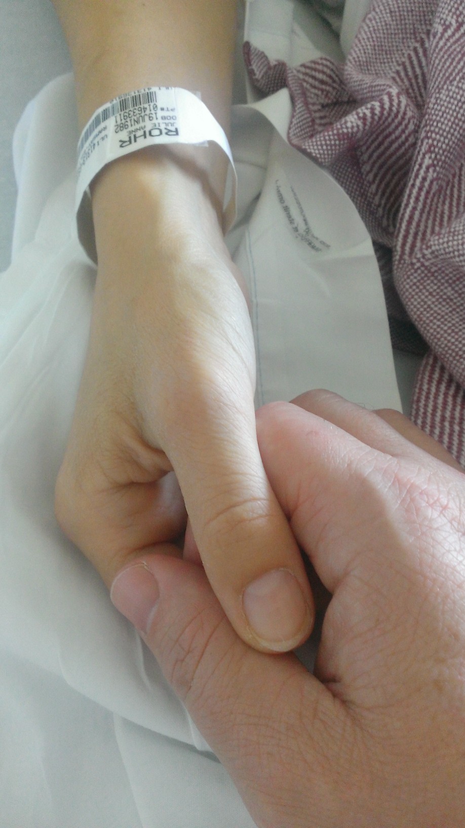  Julie Rohr holds her husband David's hand while in hospital. (David Schoor)