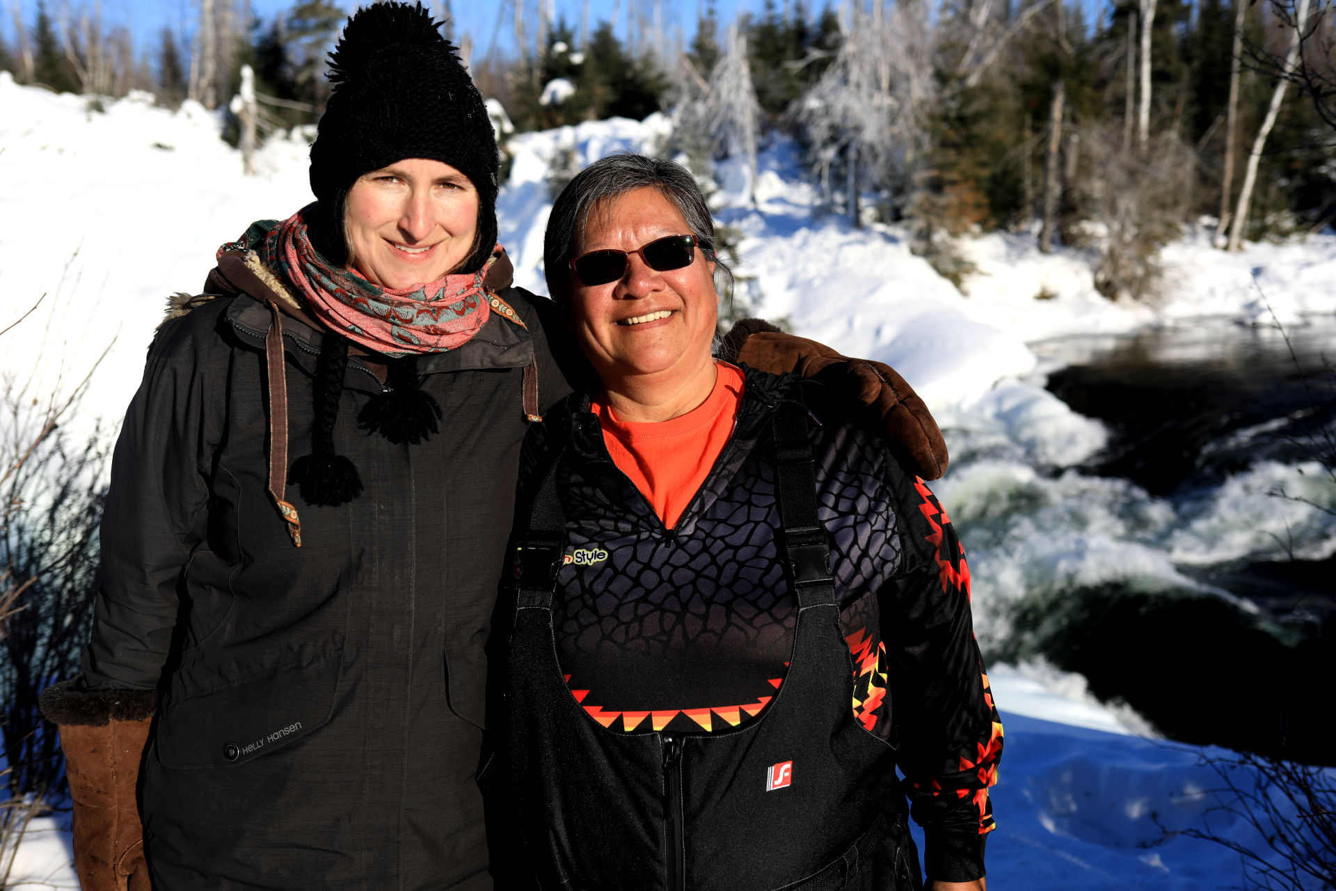 Eliza Doyle and Isabelle Hardlotte smile at the Nistowiak Falls near Stanley Mission. (Heidi Atter/CBC)