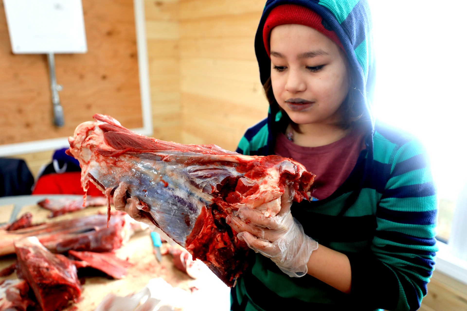 Grade 4 student Noreen Mckenzie learns how to prepare moose meat. (Heidi Atter/CBC)