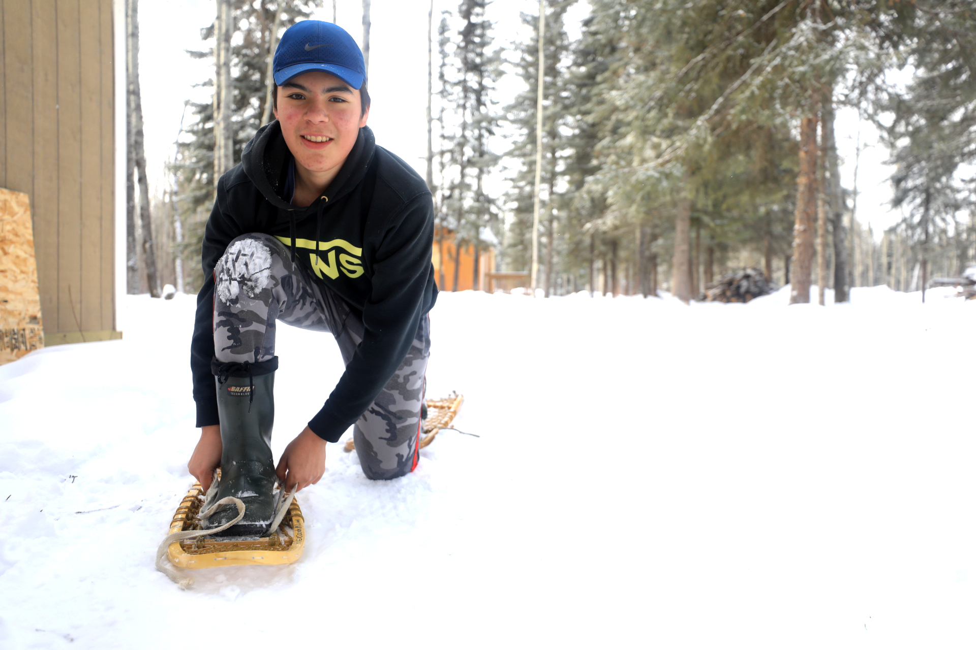 Student Peter Bird ties his snowshoes. (Heidi Atter/CBC)