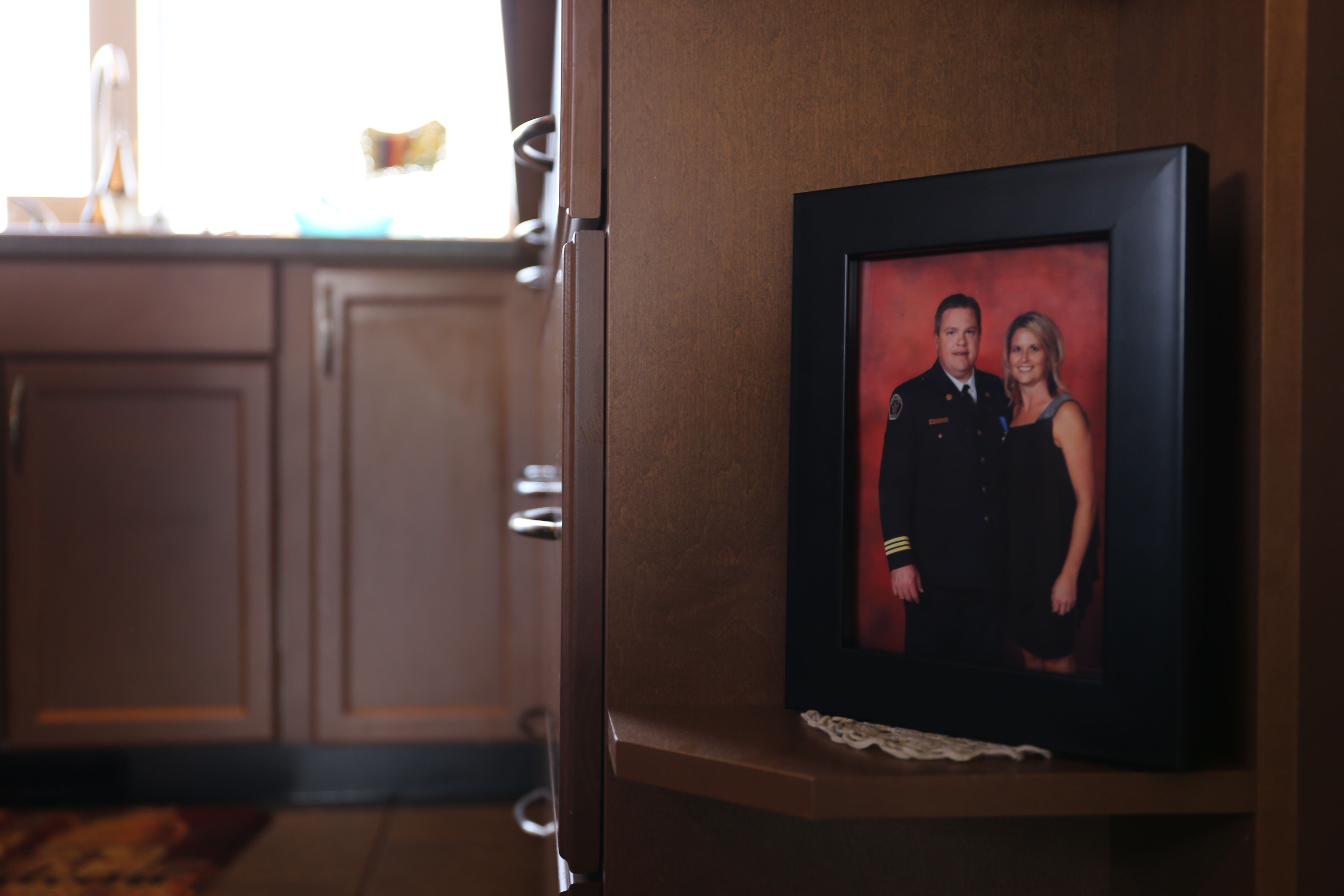 A framed photo of Jody Butz posing in uniform with his wife, sits in his family's kitchen. (Marion Warnica/CBC)