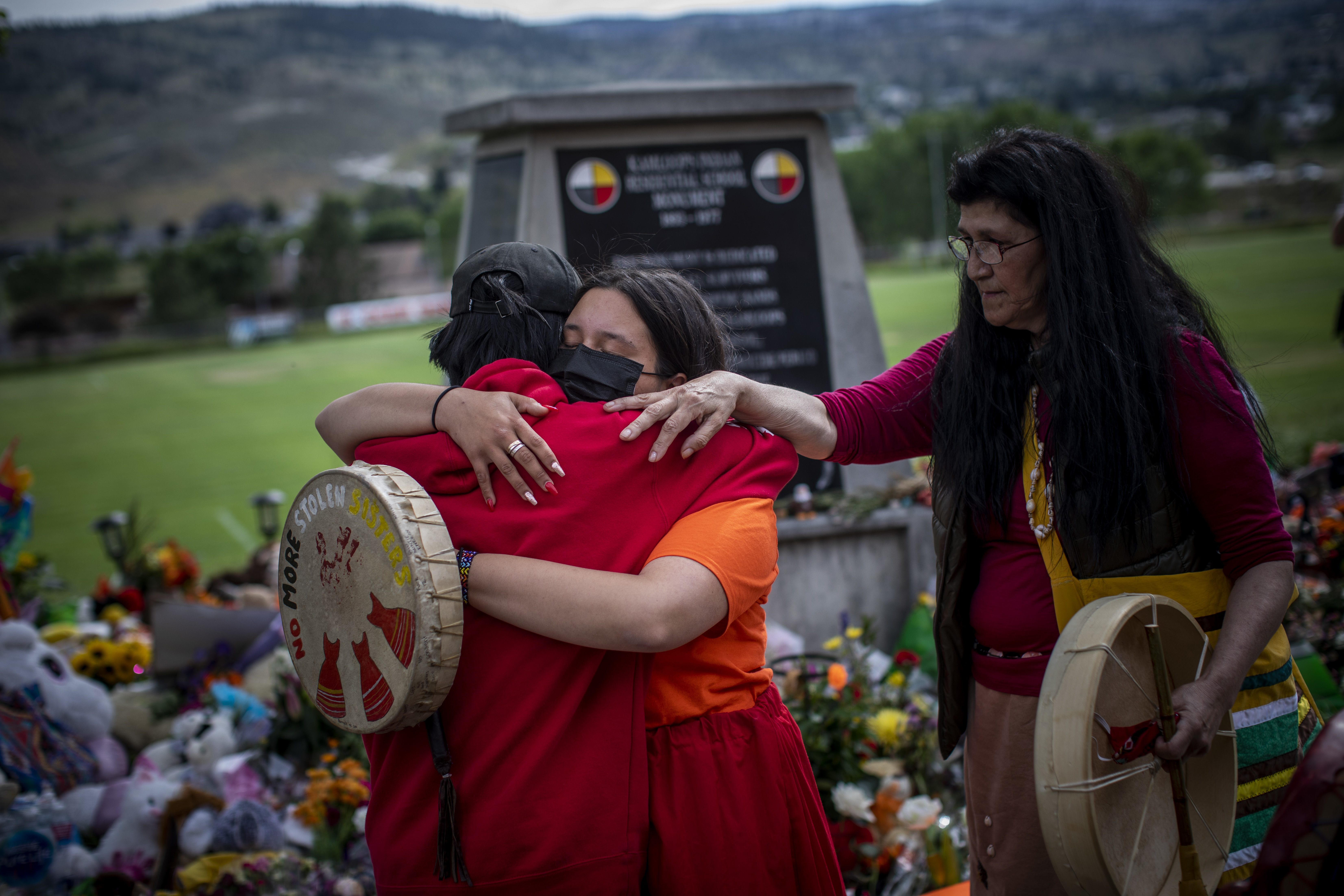 Katherine Cooper, right, from the Mosakahiken Cree Nation in Manitoba consoles her friends at a monument outside the former Kamloops Indian Residential School.