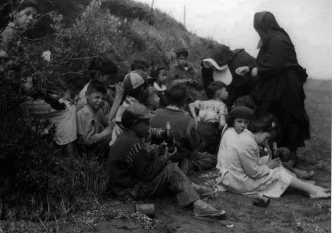 Day school students on a Lennox Island beach, being supervised by two Catholic nuns in habits, in a photo dating back to the 1940s or 1950s. (From the collection of Judy Clark)