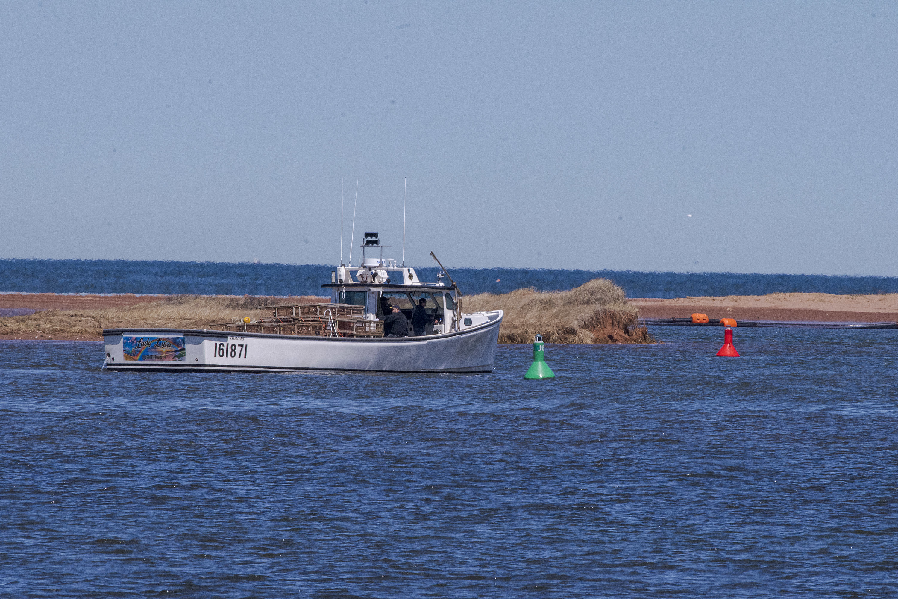 The channel out of Malpeque harbour is well marked and it can get congested with lobster boats and mussel harvesters going back and forth. There is a dredger working to deepen the channel, but fishermen say that almost as soon as sand is pumped out, it begins to refill again and that makes it dangerous especially for boats laden with heavy lobster traps. (Brian McInnis/CBC) 