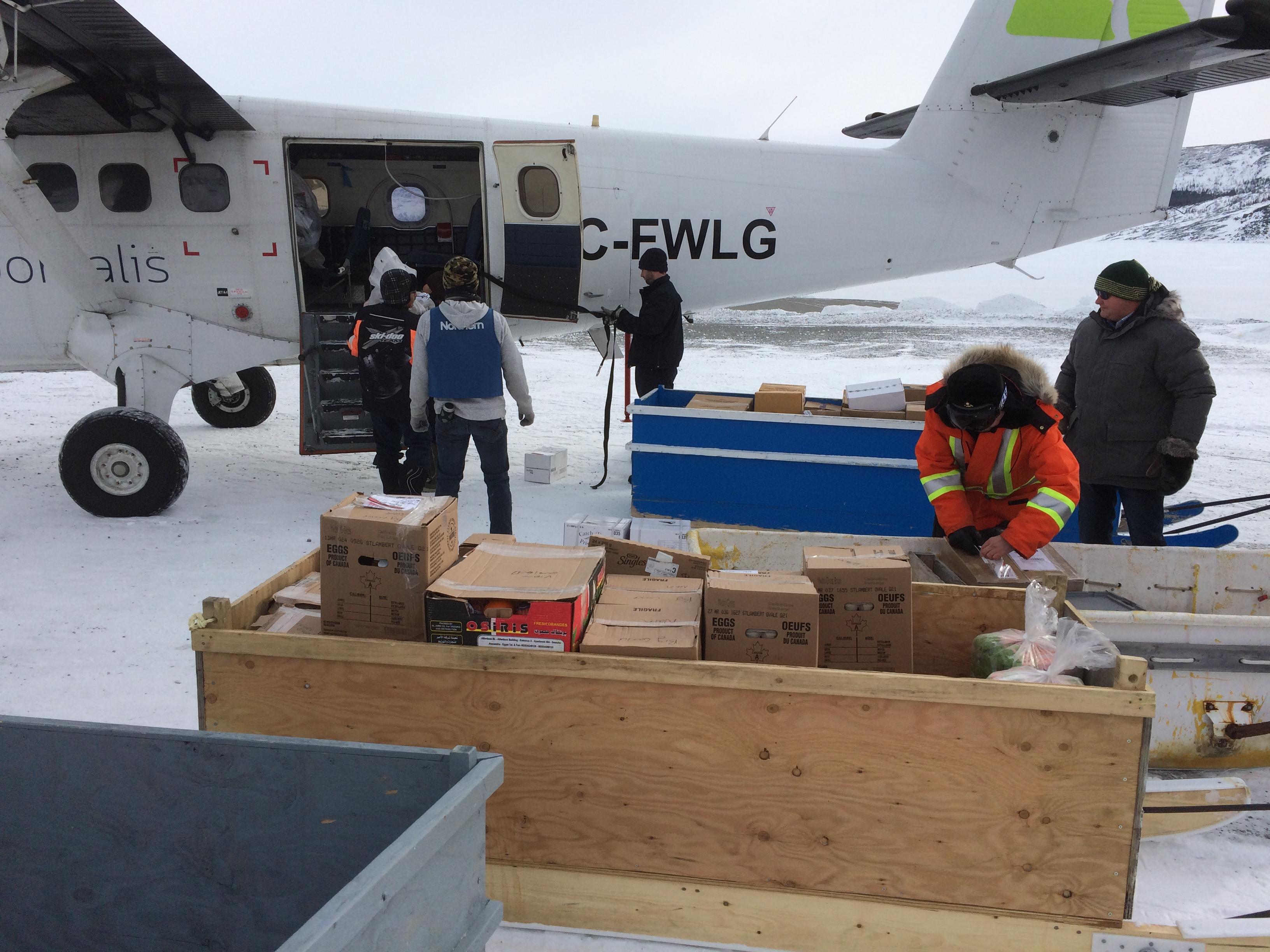 Moving cargo from the plane to the komatiks. (Jen White/CBC)