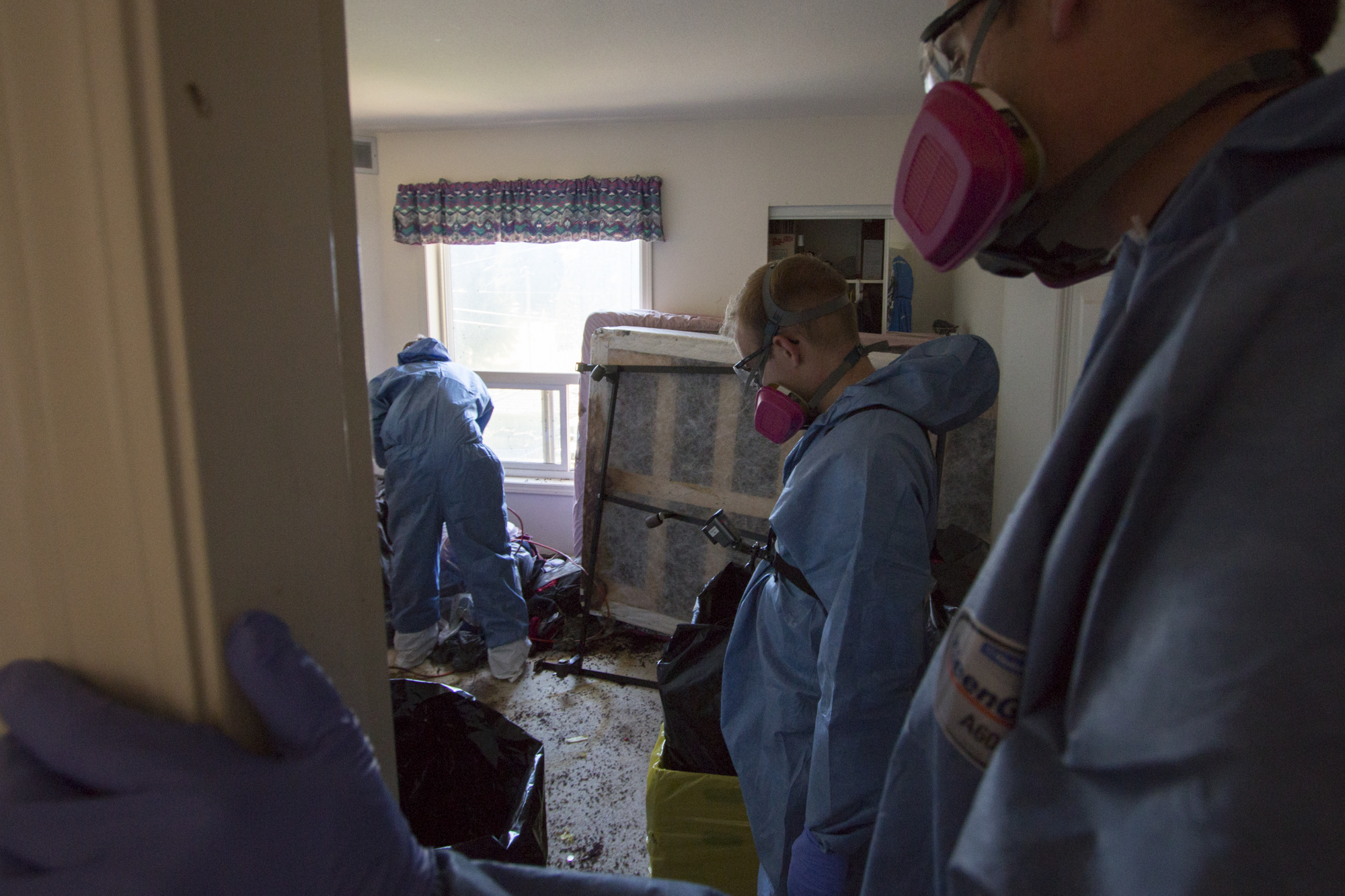 Kreklau and his co-workers look into the bedroom where the deceased was found. Most of the furniture will need to be taken apart and disposed of. (Tina Lovgreen/CBC)