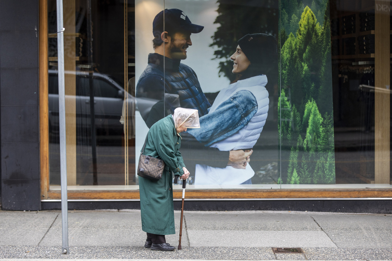 A woman waits for a bus on a near empty Robson Street in downtown Vancouver on March 30, 2020. (Ben Nelms/CBC Vancouver)