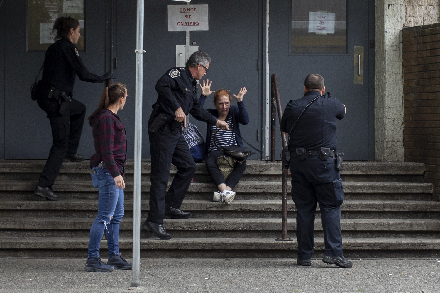 Vancouver police officers draw their guns while arresting a woman for reports of an illegal weapon in the Downtown Eastside of Vancouver on May 20, 2020. (Ben Nelms/CBC Vancouver)