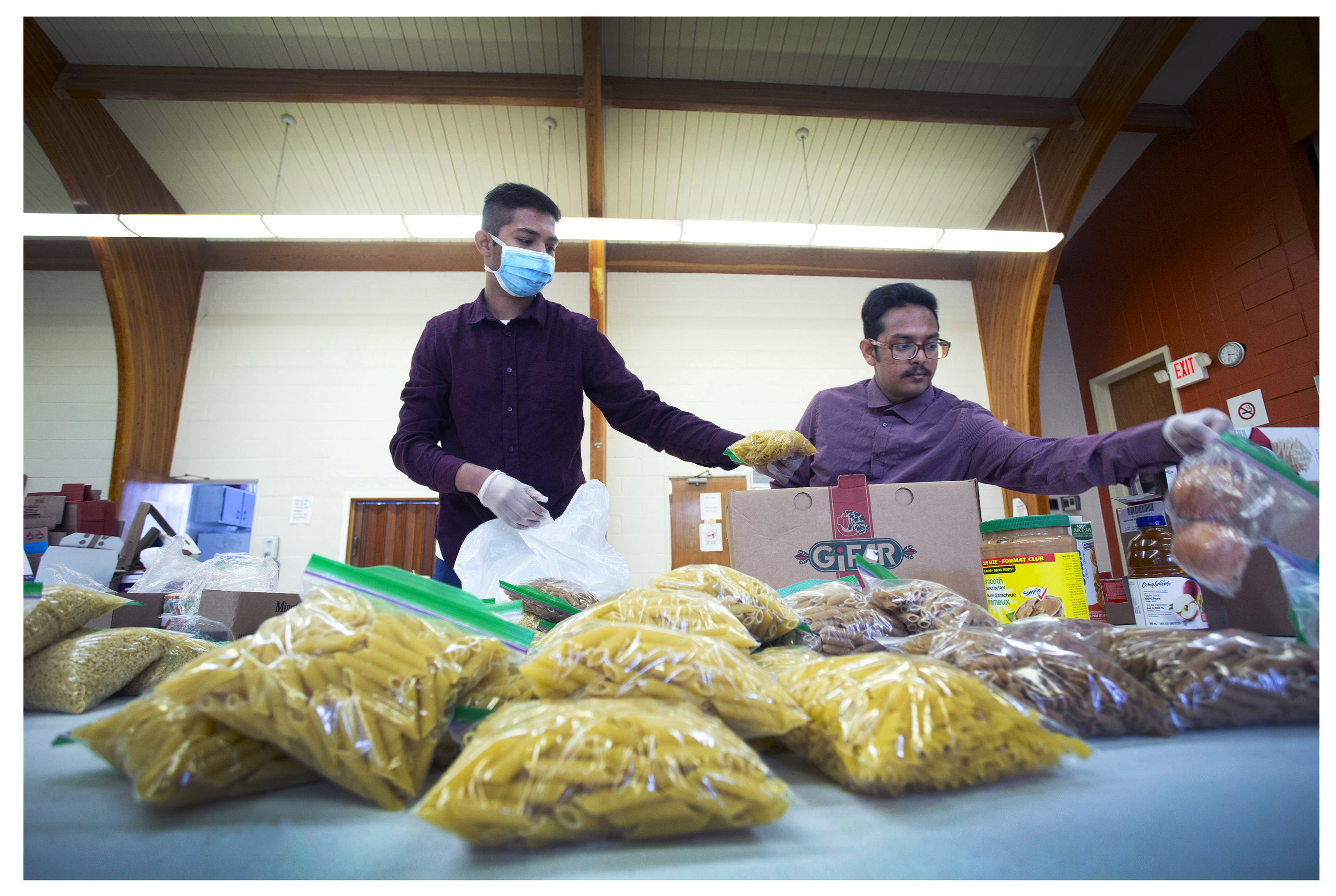 Food NL volunteers Mahmudiel Islam Shourov and Adid Rahman prepare hampers for distribution. (Photo by Paul Daly) 