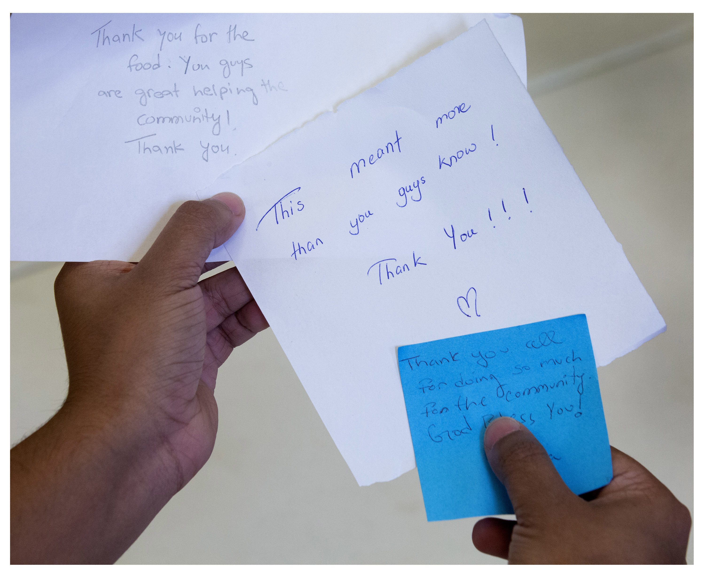 Adid Rahman, a business student at Memorial University, shows some of the notes that have been left for NL Eats volunteers when they deliver  food hampers in St. John’s. The group has been using space at St. David’s Presbyterian Church in St. John’s.  (Photo by Paul Daly)