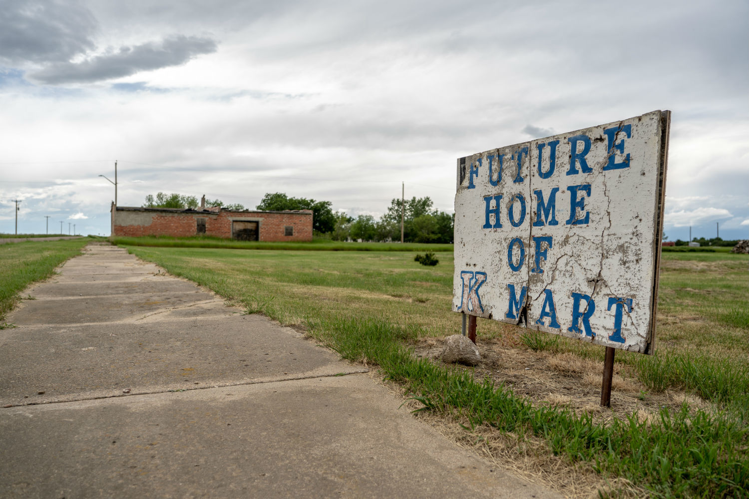 A sign in front of an empty field in Nemiskam, Alta., reads 'Future home of K-Mart.' (Vincent Bonnay/Radio-Canada)