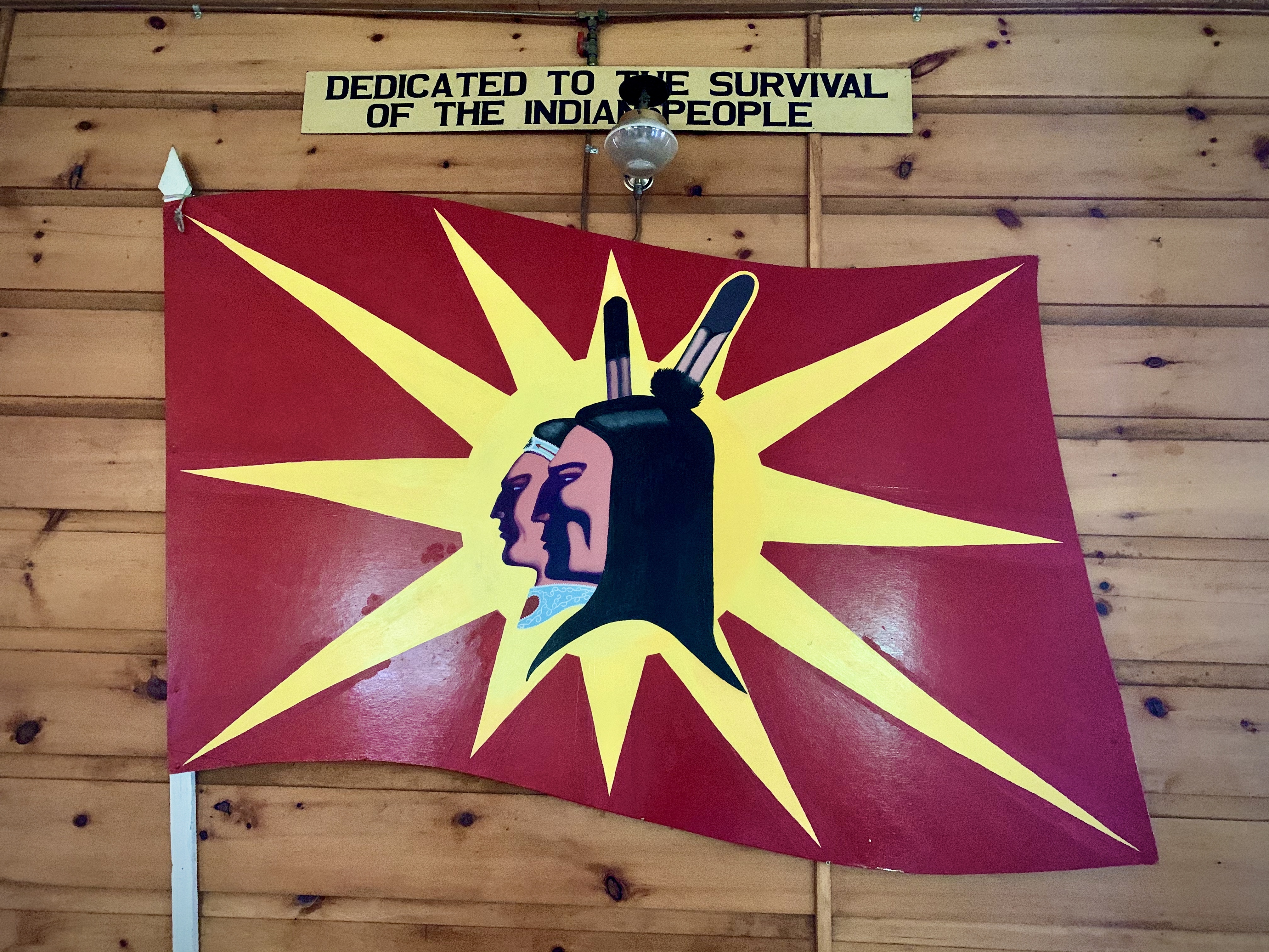 One of Hall's last paintings, of a new version of the warrior flag, hangs inside Kahnawake's Kanien'kehà:ka Nation Longhouse. (Jessica Deer/CBC)