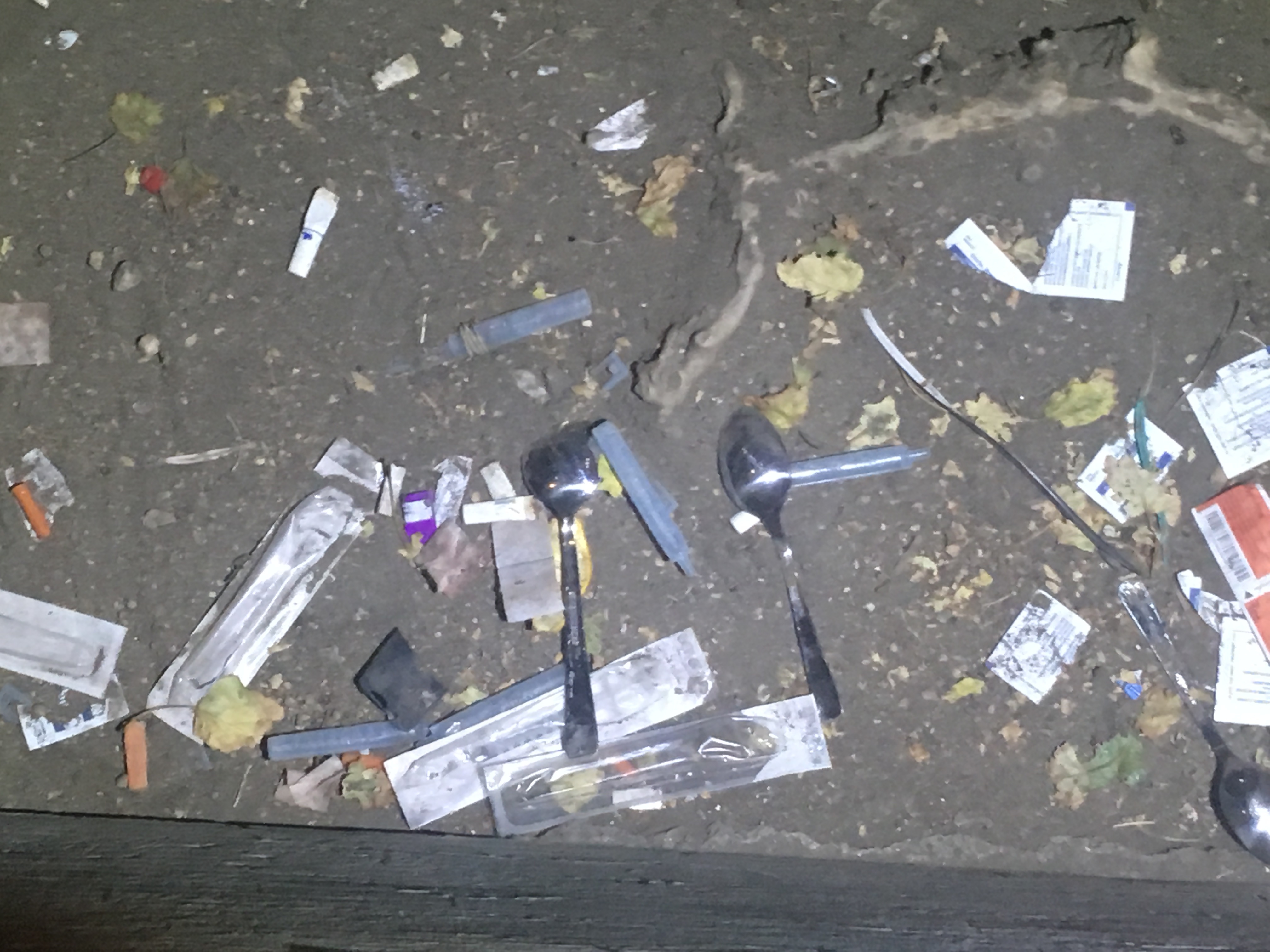 A patch of ground near a needle exchance in Pleasant Hill is littered with needles and spoons used by injection drug users. (Matt Garand/CBC)