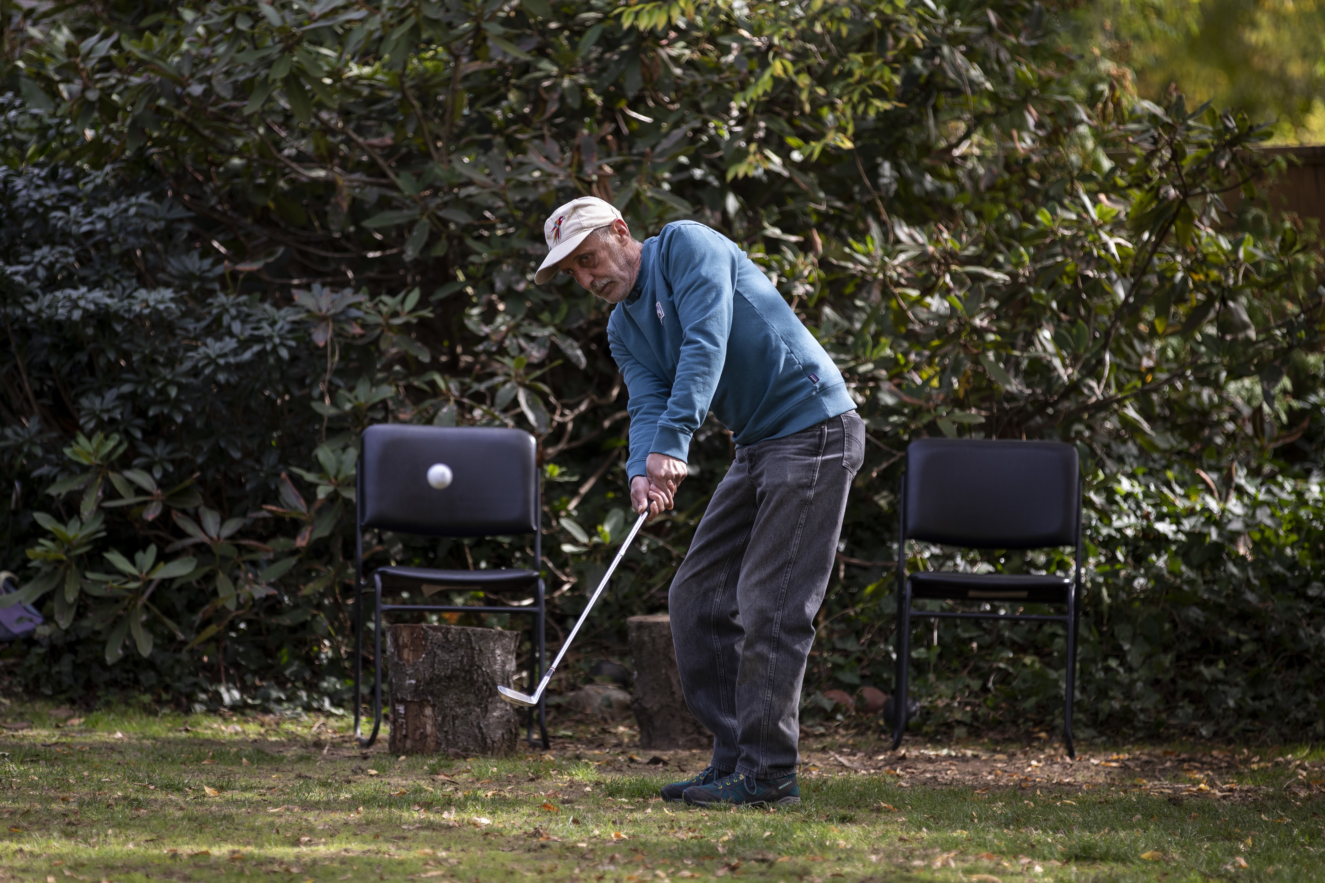 Charlie Smyth enjoys hitting the golf ball in his backyard now that he has settled into his housing unit. (Ben Nelms/CBC)