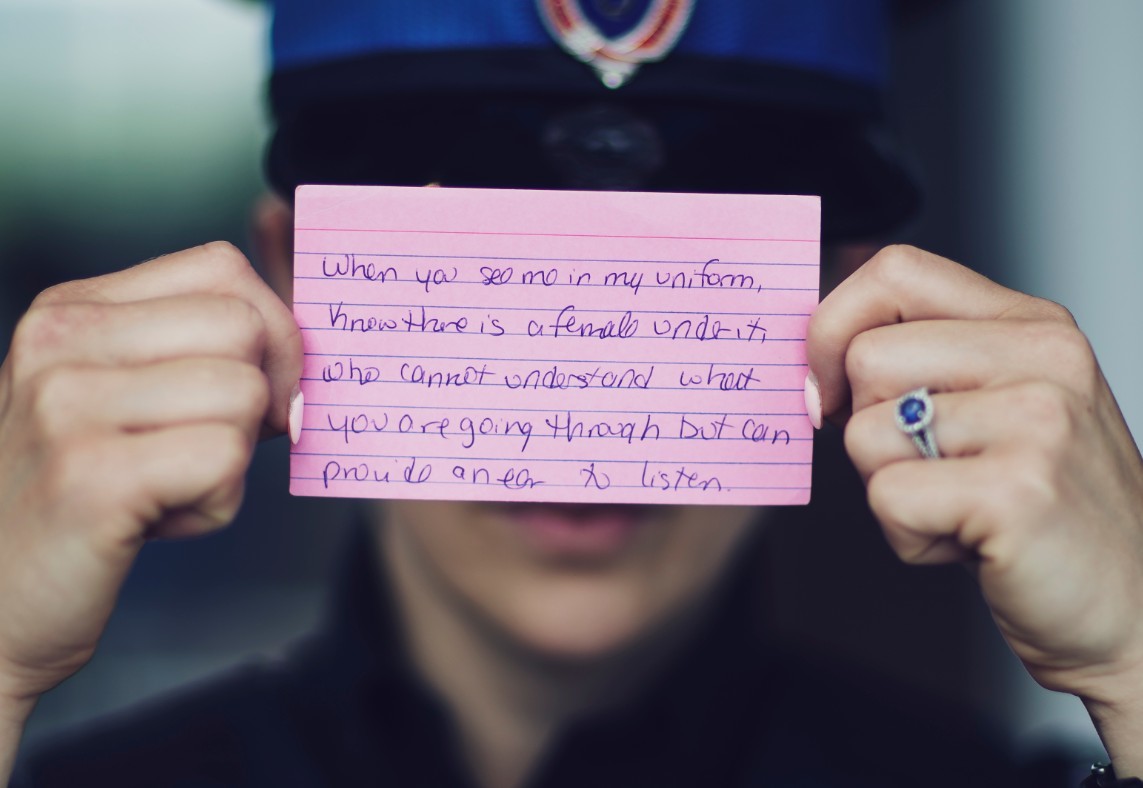 An RNC officer holds the card she wrote. It reads: 'When you see me in my uniform, know there is a female under it, who cannot understand what you are going through but can provide an ear to listen.' (Dave Howells)