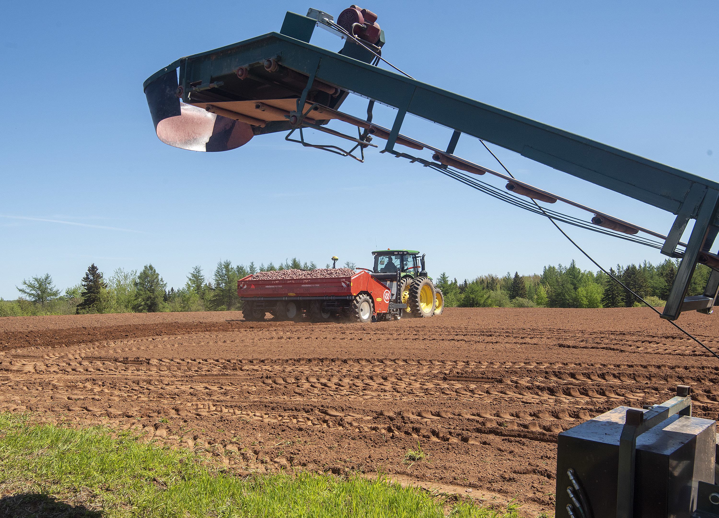 A farmer guides his tractor down the field. Spring planting means 12-14 hour days and modern equipment extends those hours long after the sun sets. (Brian McInnis)