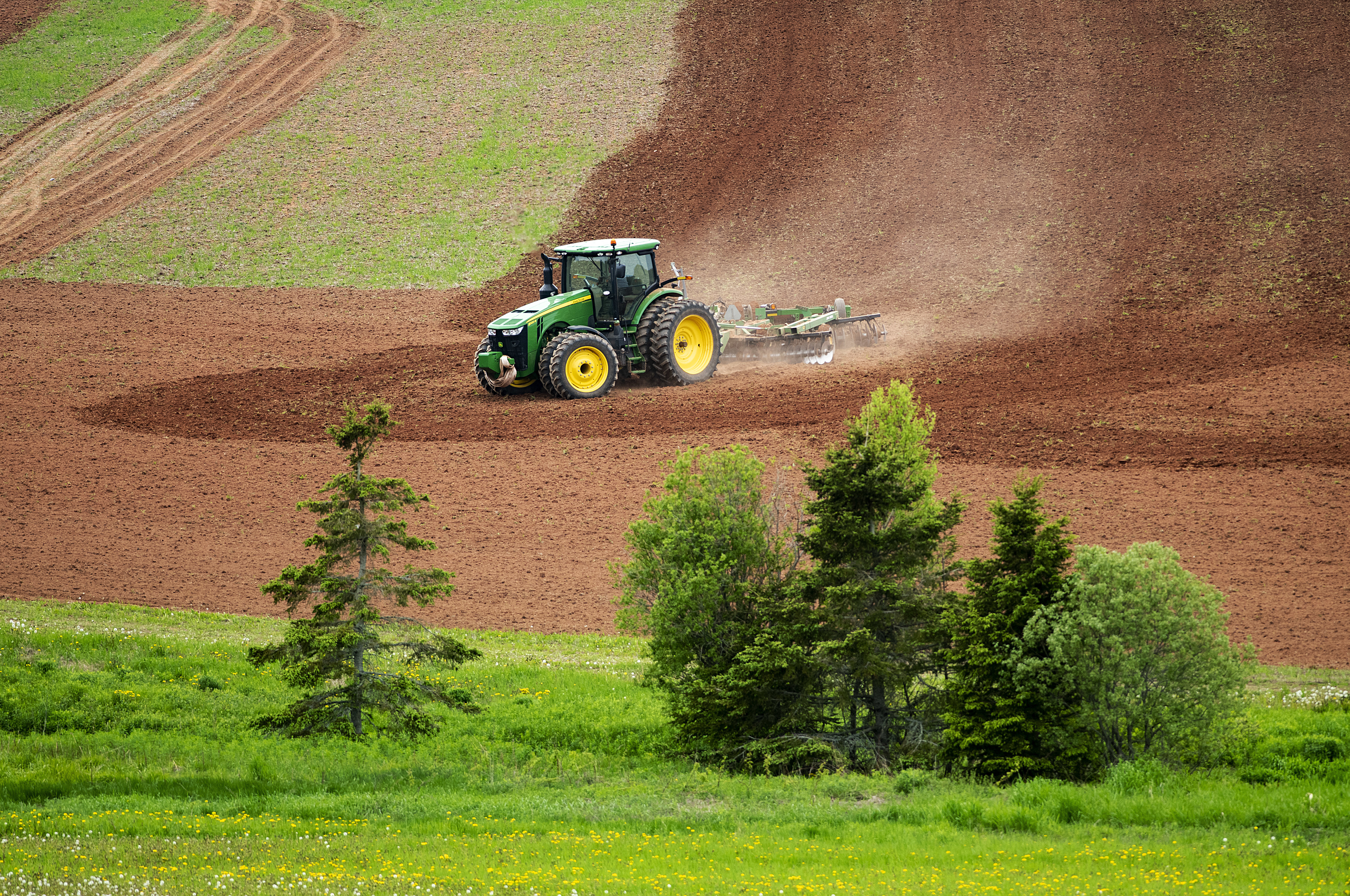 A farmer skillfully brings his tractor to the edge of the field and a stand of trees recently in Hampshire. (Brian McInnis)