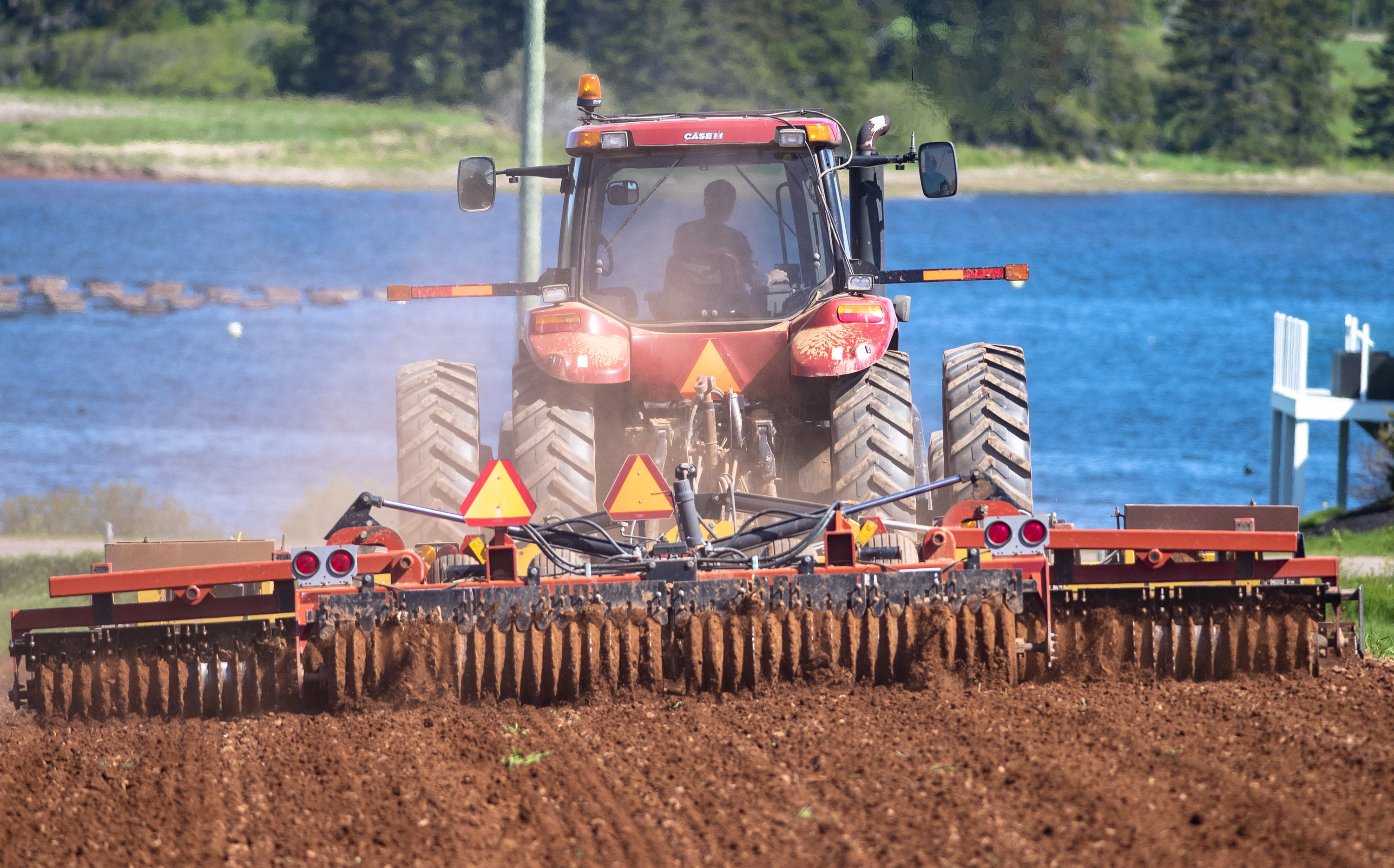 For generations, Islanders have made a living on both land and water and that tradition continues as a farmer plows his field near the Grand River, which supports an oyster fishery. (Brian McInnis)