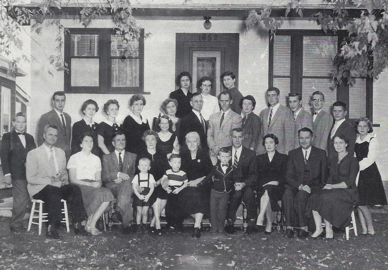 The Peters family gathers in front of the family home on Pacific Avenue W. in Winnipeg. Frank, seated at the far left, was seven years old when the family fled Russia. His son Robert is standing, centre, wearing a bowtie. The author's father, Henry Schroeder, stands in the middle row (second from the right), and Henry's mother, Melita, stands nears the centre (sixth from the left), with one of her daughters in front of her. (Robert Peters)