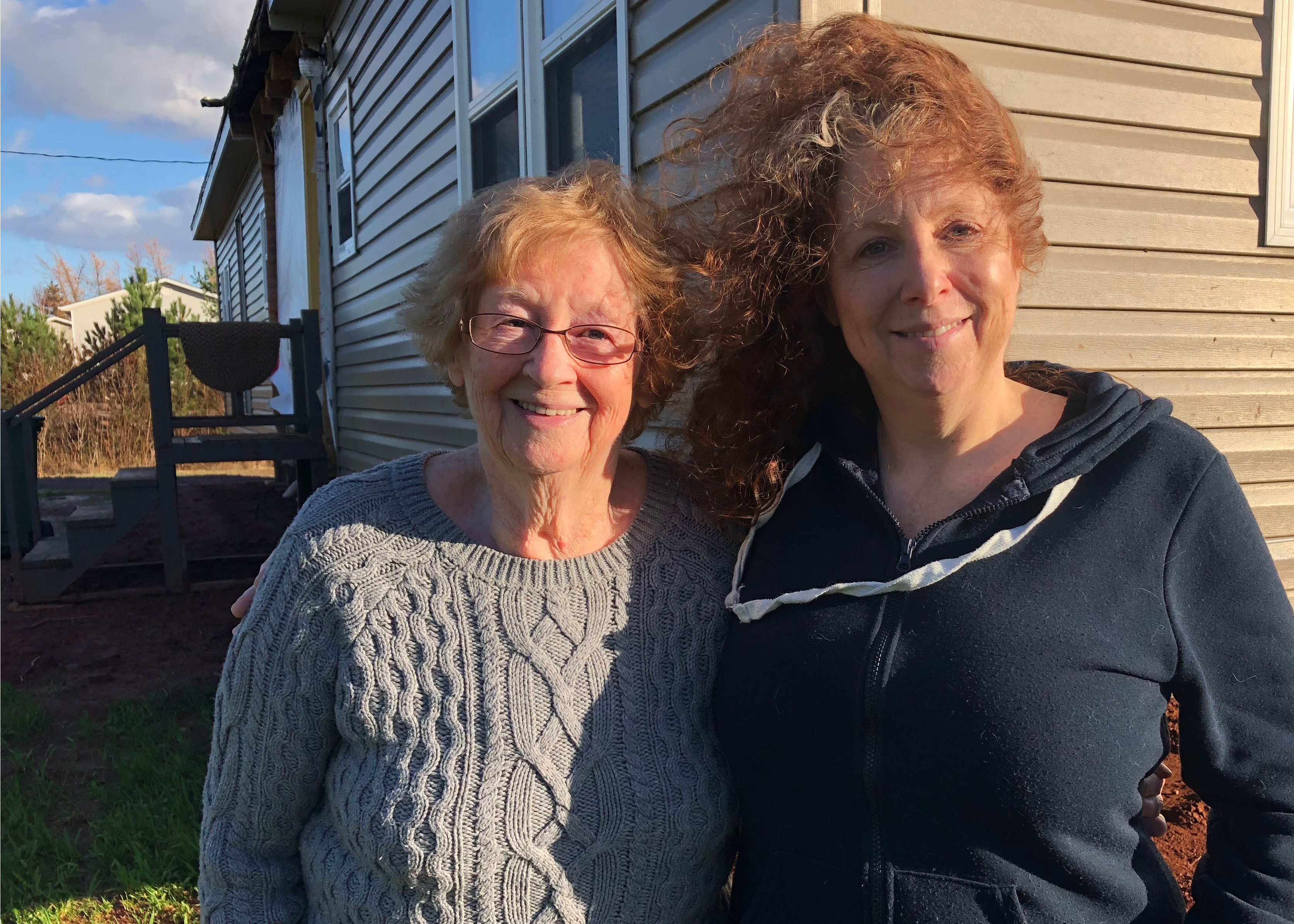 Pam Detlor (right) and her mother Jeannette Detlor outside their trailer which they moved to land just outside Summerside. Jeannette said she would have had to leave it if it wasn't for the help of her daughter. (Laura Meader/CBC)