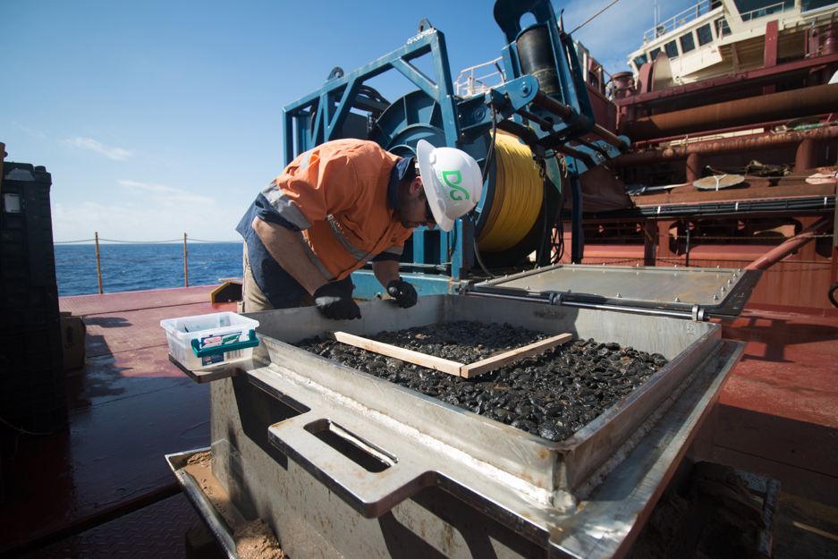 A worker examines polymetallic nodules as part of DeepGreen's ongoing evaluation of metals lying on the seabed in the Clipperton-Clarion Fracture Zone. (DeepGreen Metals Inc.)