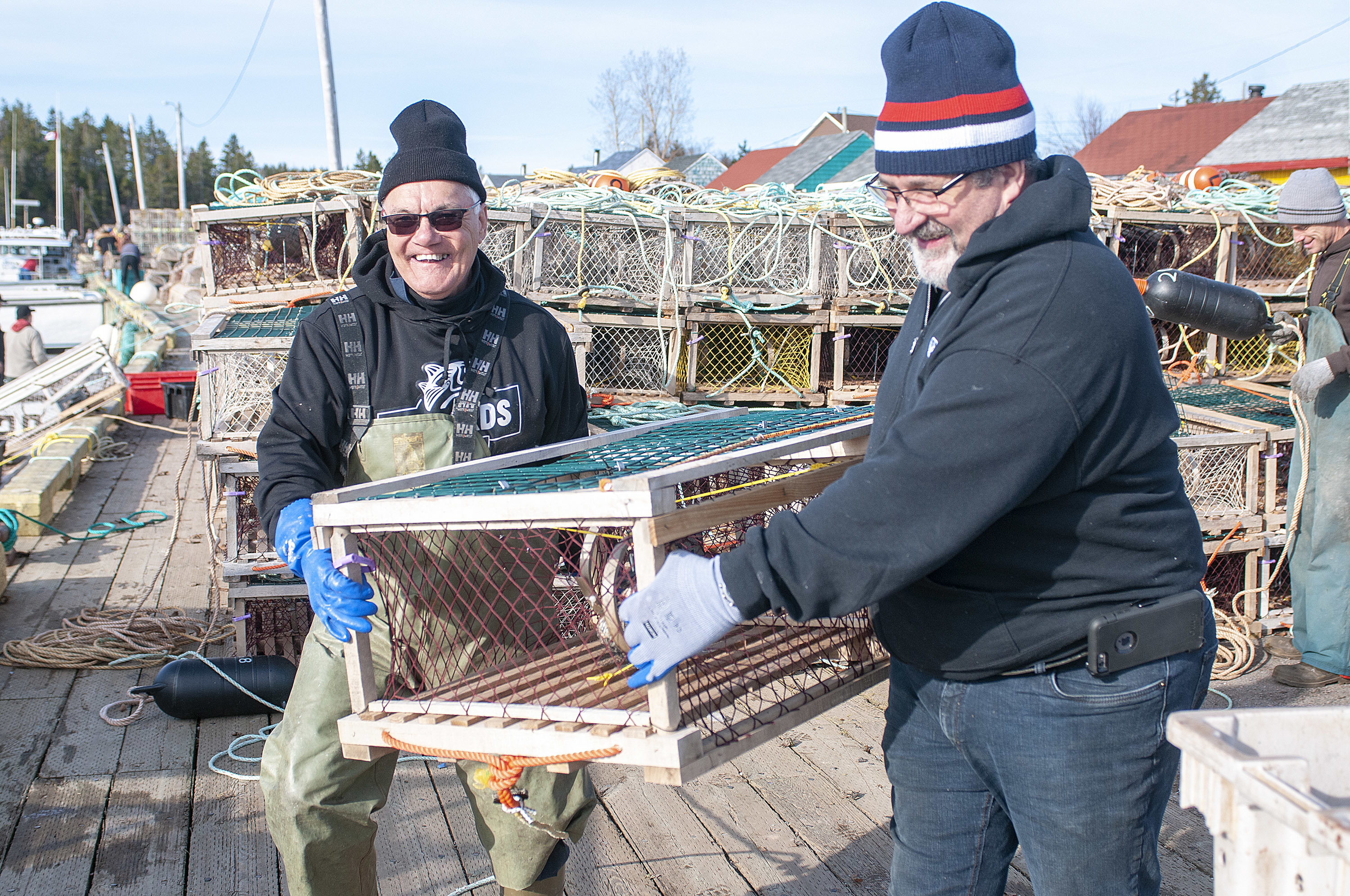 Captain Alfred Gallant, left, of Mister In-Between and Larry Court, load traps onto the boat after setting their first load earlier in the morning. Each boat is allowed approximately 300 traps and they split those between two runs. (Brian McInnis)