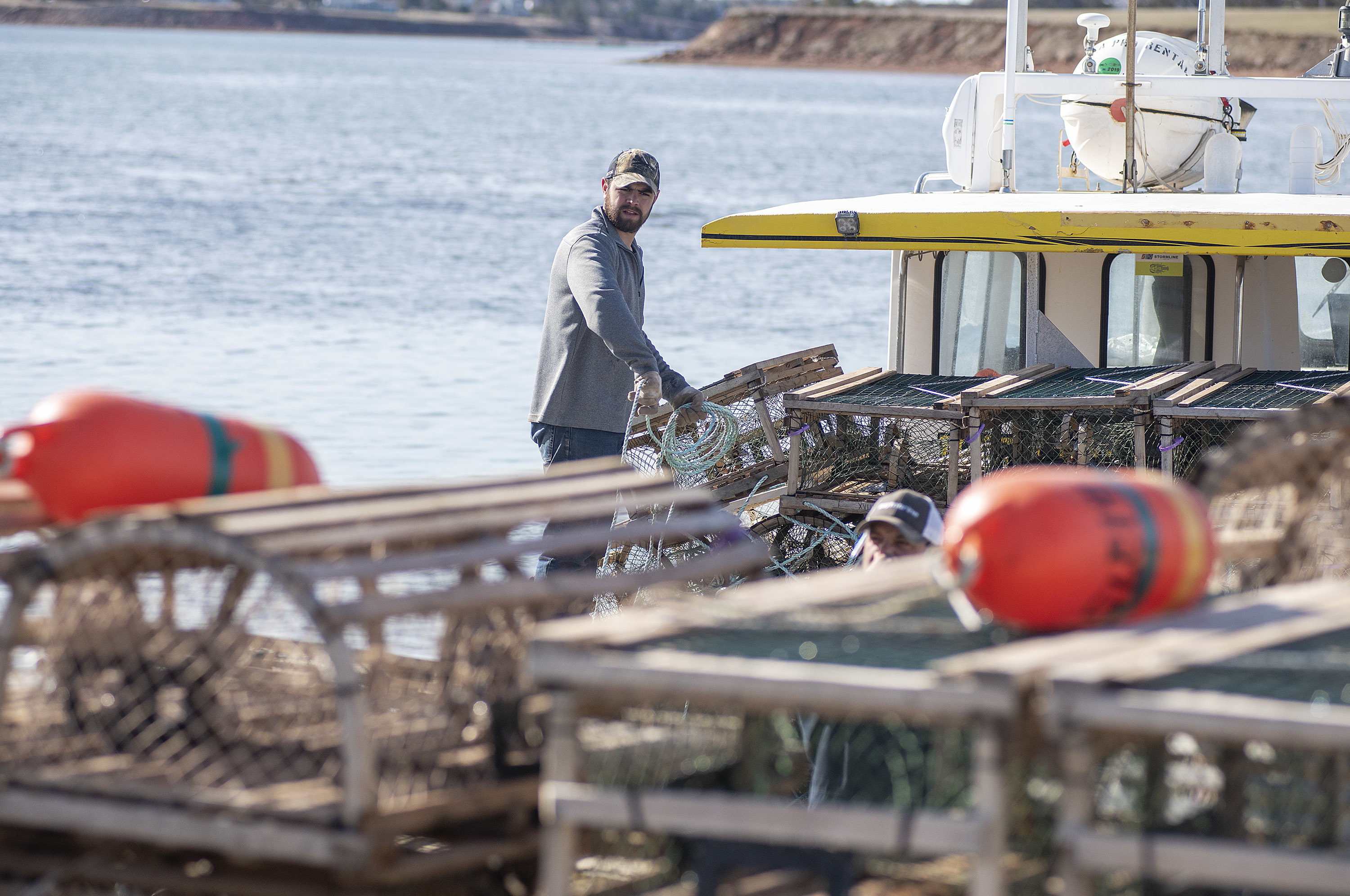 A fisherman prepares the rope that is tied to the traps. Making certain the knots are tied properly and the rope is not tangled in the traps is an art in itself. If a crew member got his foot tangled in the rope as a trap was being dropped into the water he has a good chance of being pulled overboard. (Brian McInnis)