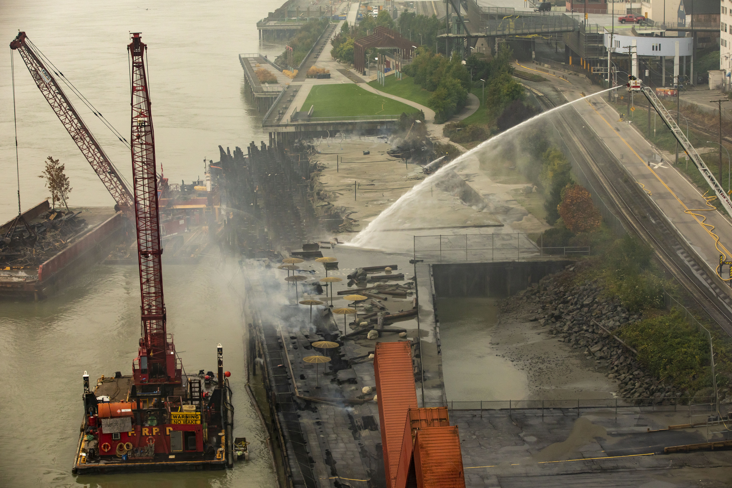 Fire crews work to put out a fire under the historic New Westminster Pier in New Westminster, B.C., on Sept. 16, 2020. It continued to smoulder for 11 days. Westminster Pier Park is expected to re-open in February 2021. (Ben Nelms/CBC Vancouver)