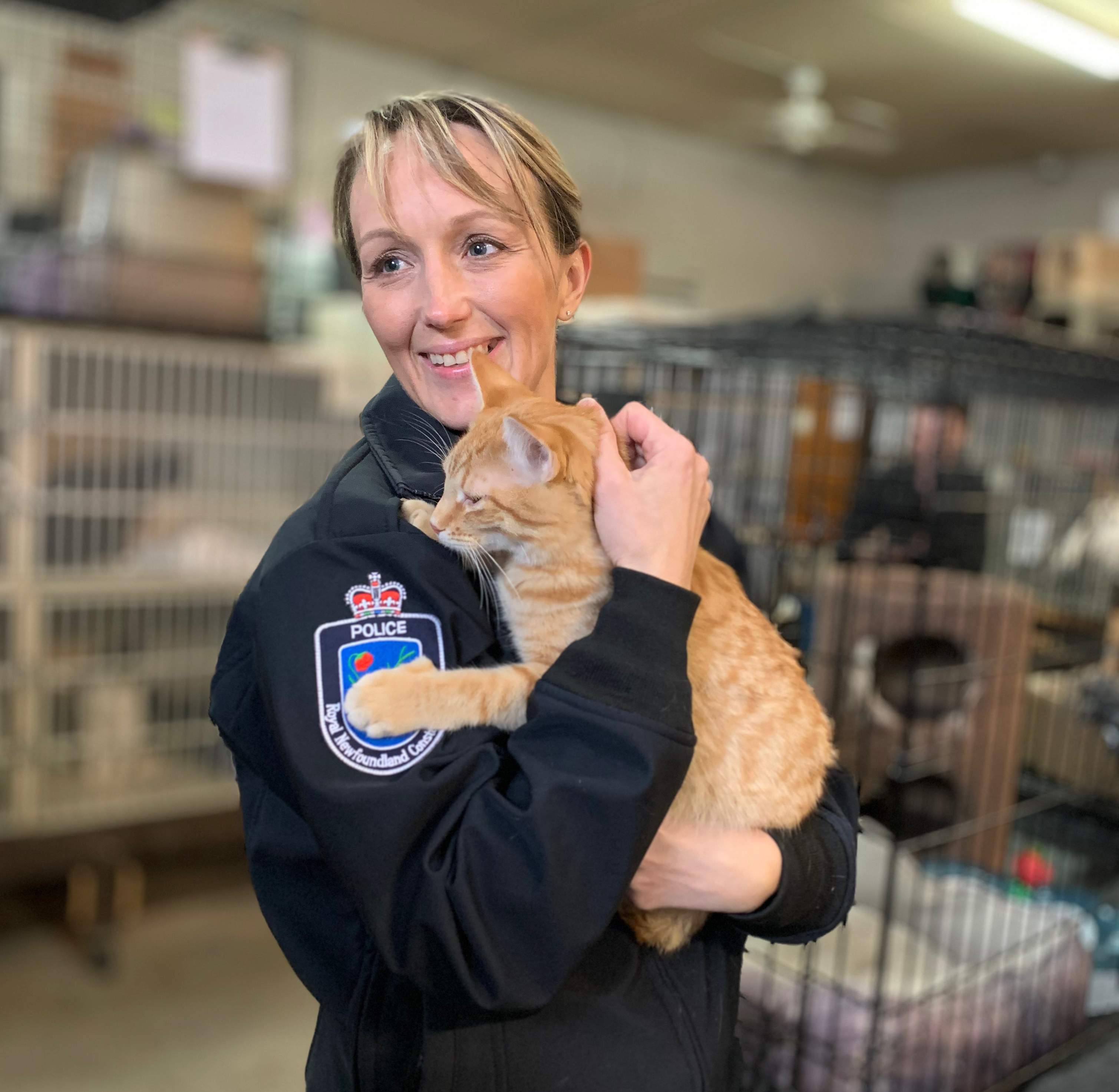 Const. Shawna Park cuddles an adoptable cat at the NL West SPCA. (Ariana Kelland/CBC)