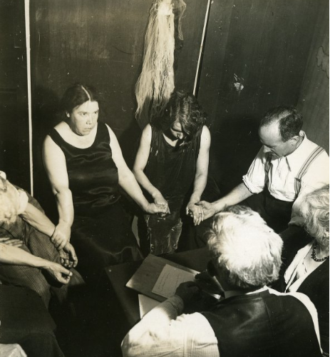 Guests hold hands in T.G. Hamilton's seance room.