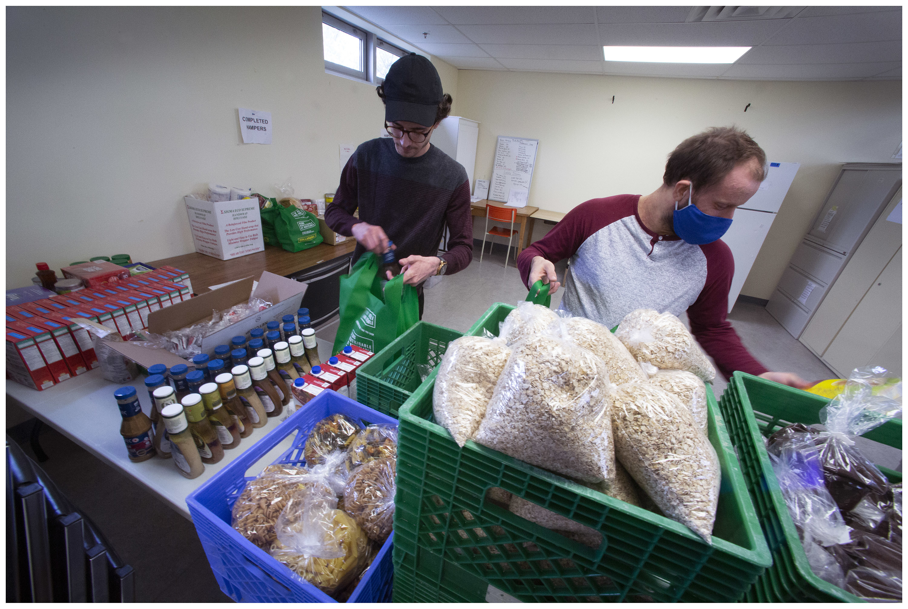 Jared Davis and Nick Baxter prepare food hampers at The Gathering Place. The non-profit organization changed its tactics when the lockdown started. (Photo by Paul Daly)