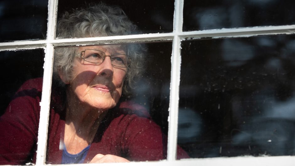 Rosemary Hopkinson, 79, is pictured through her house window in West Vancouver during the pandemic.
