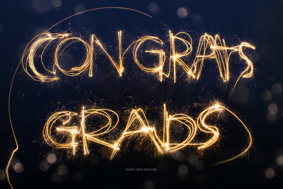 A sparkler spells out, "Congrats, grads," against a dark sky.