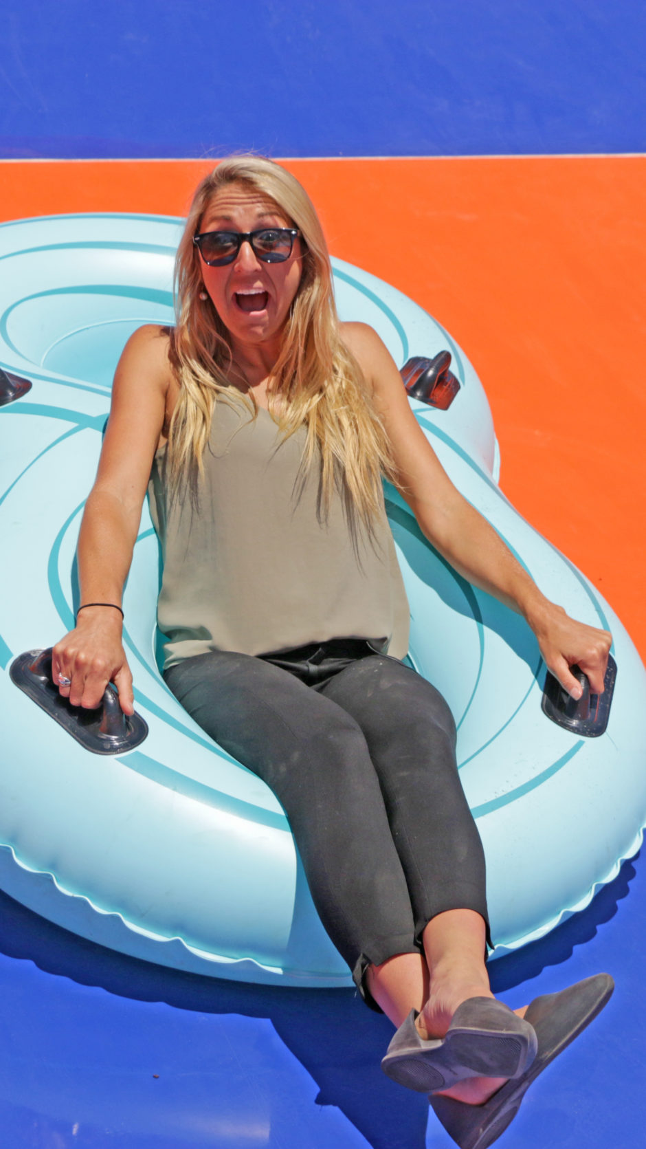 Waterslide designer Emily Colombo sits on a raft on a waterslide.