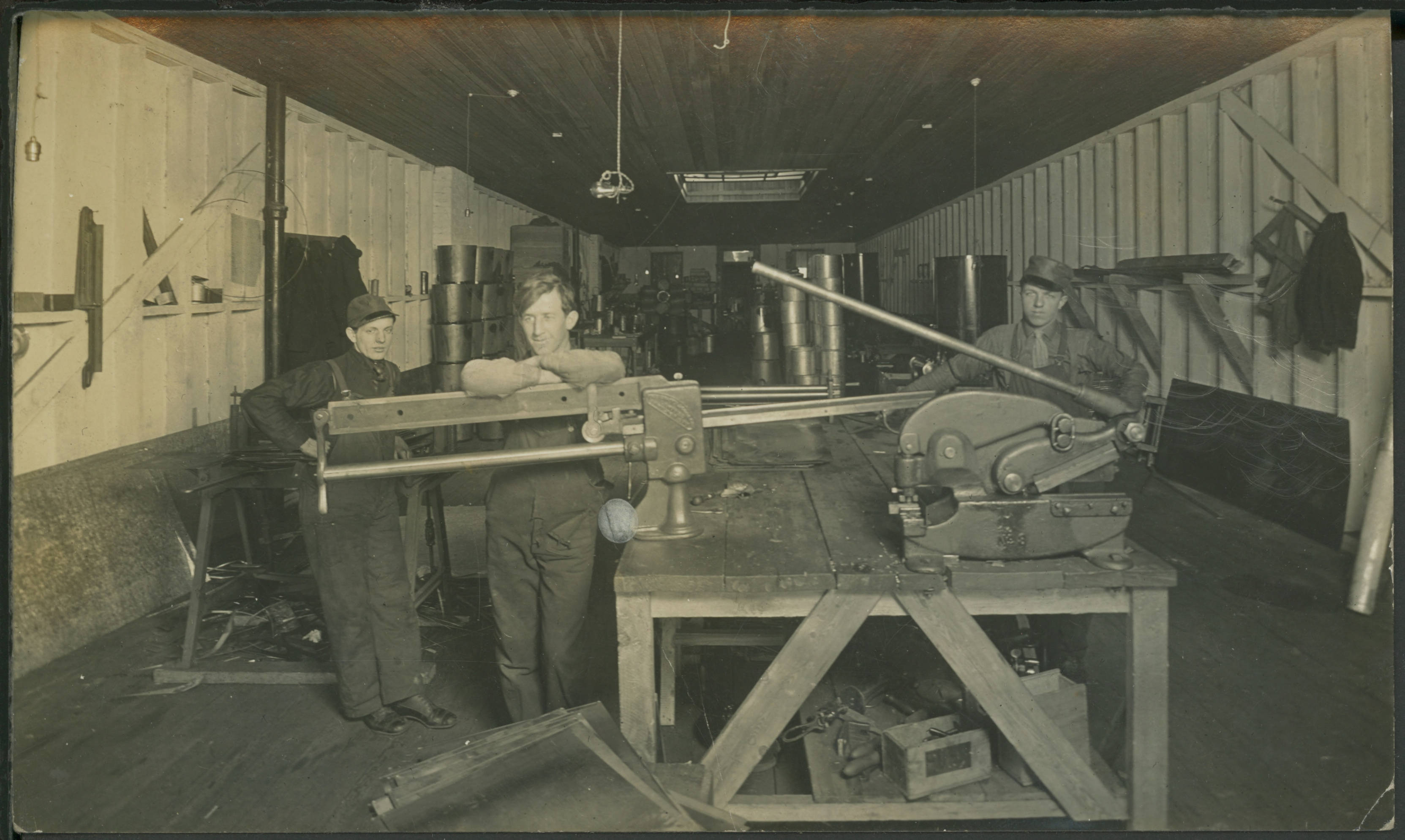 Three men stand in a railway shop in this Winnipeg postcard from 1911. (Martin Berman Collection/Winnipeg Public Library)