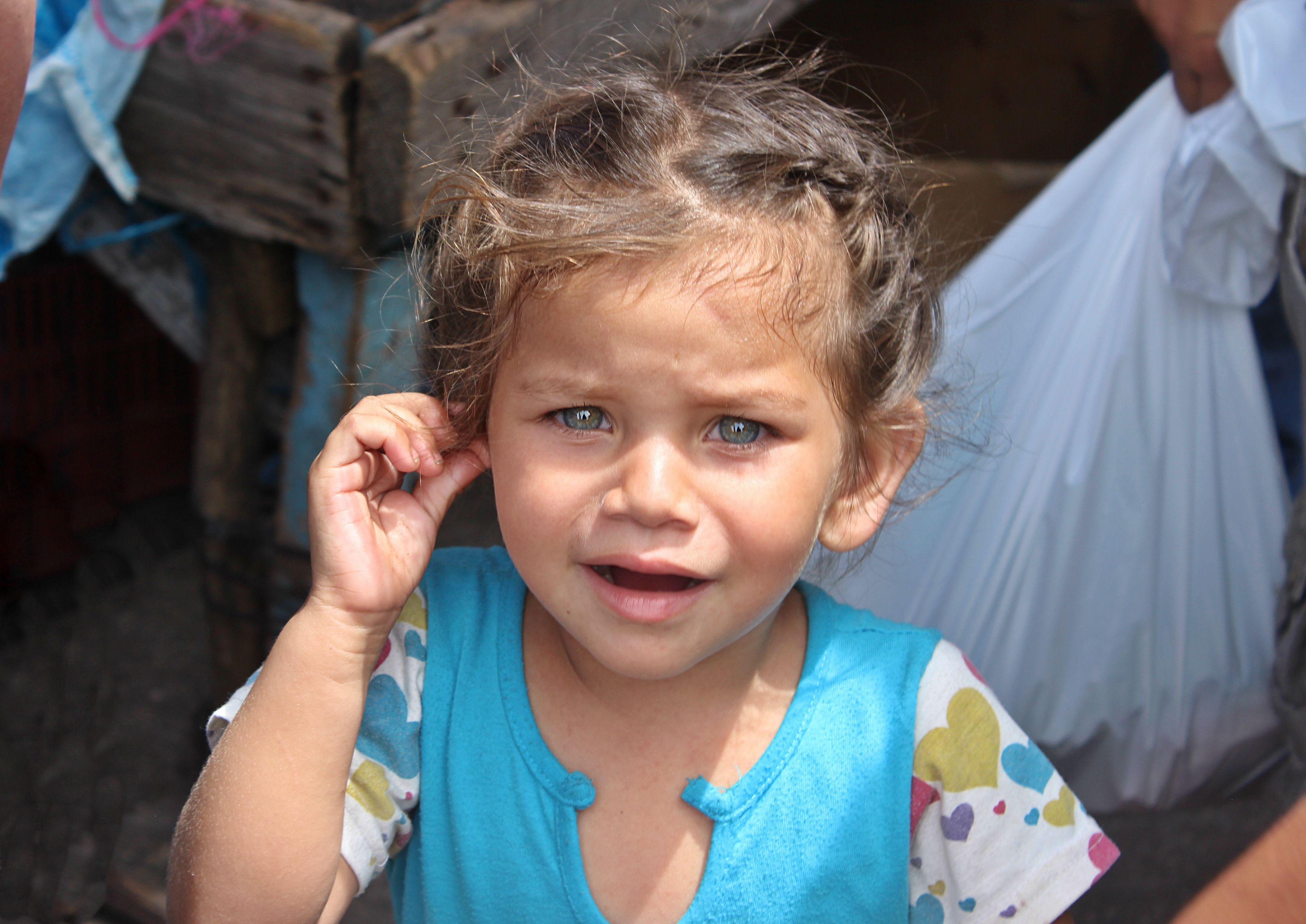 Four-year-old Génesis Naomi Sierra cries while walking through El Mayoreo, Tegucigalpa's farmers market, with her mother. (María José Burgos/CBC)