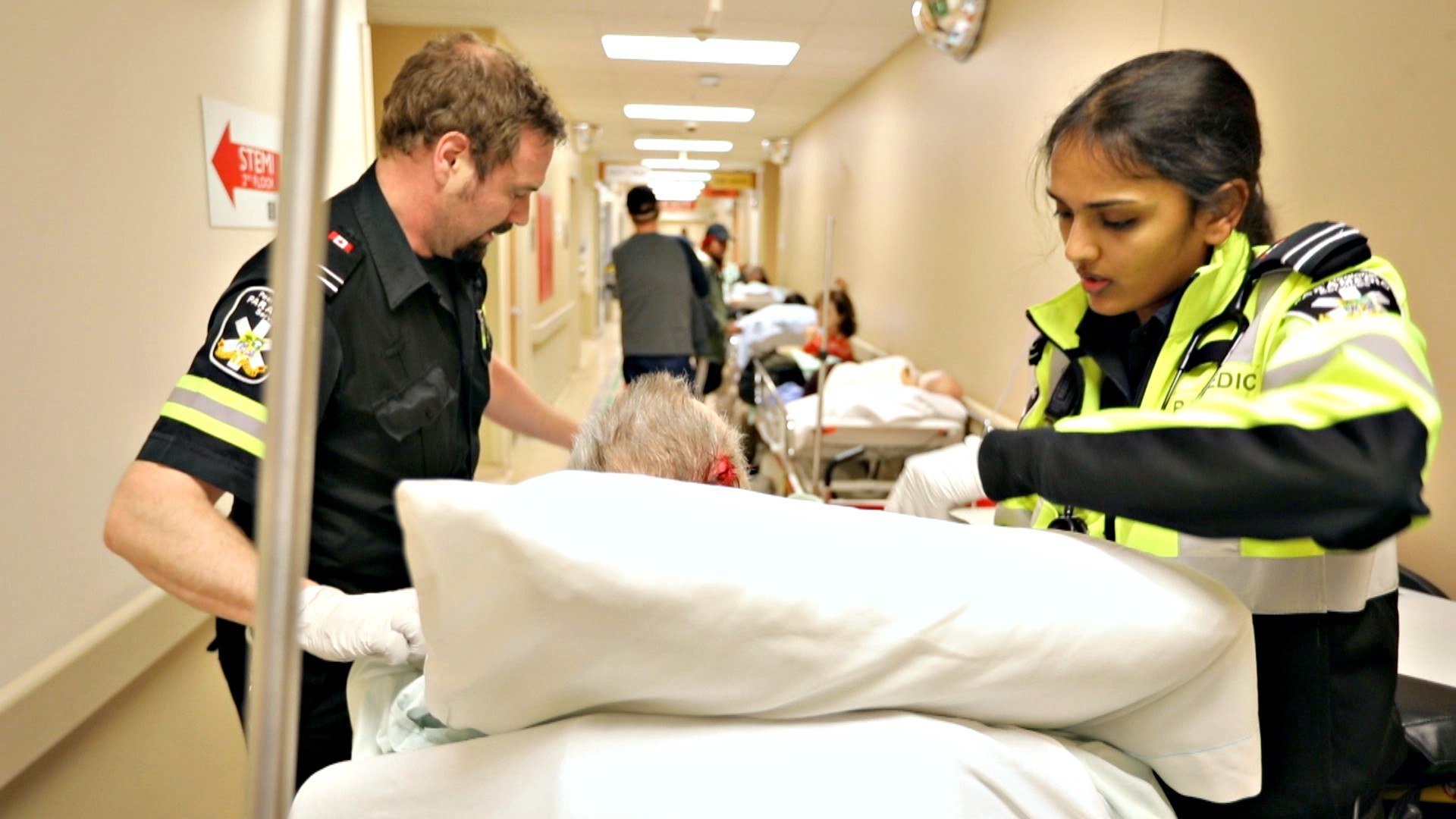 Shortly before 7 p.m., paramedics bring another patient into the already-crowded hallway. (Paul Borkwood/CBC News)