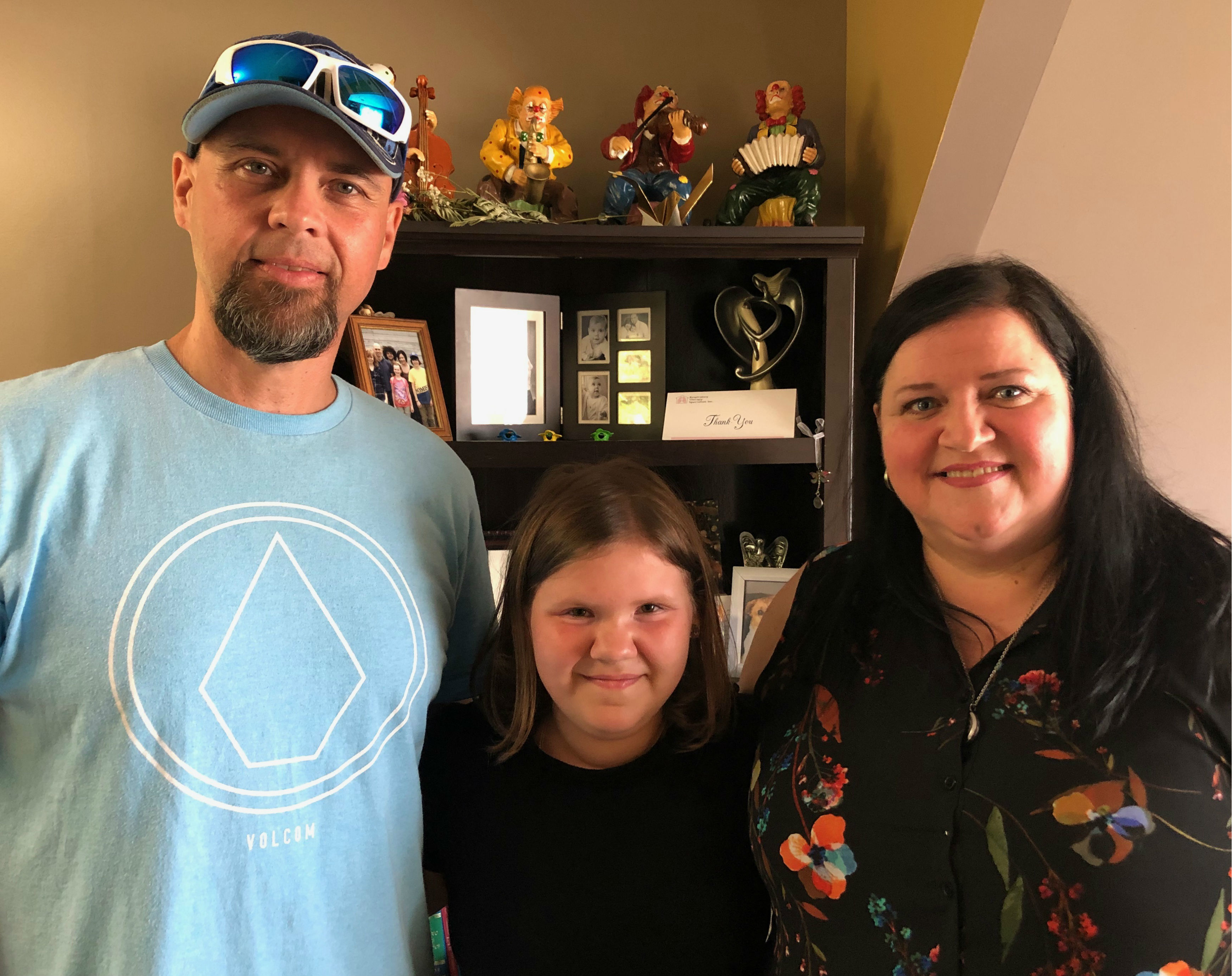 Brygette Park (centre) with her dad, Trevor Park (left), and her mom, Penny Lambert (right), at the family's home in Gillams. (Jen White/CBC)