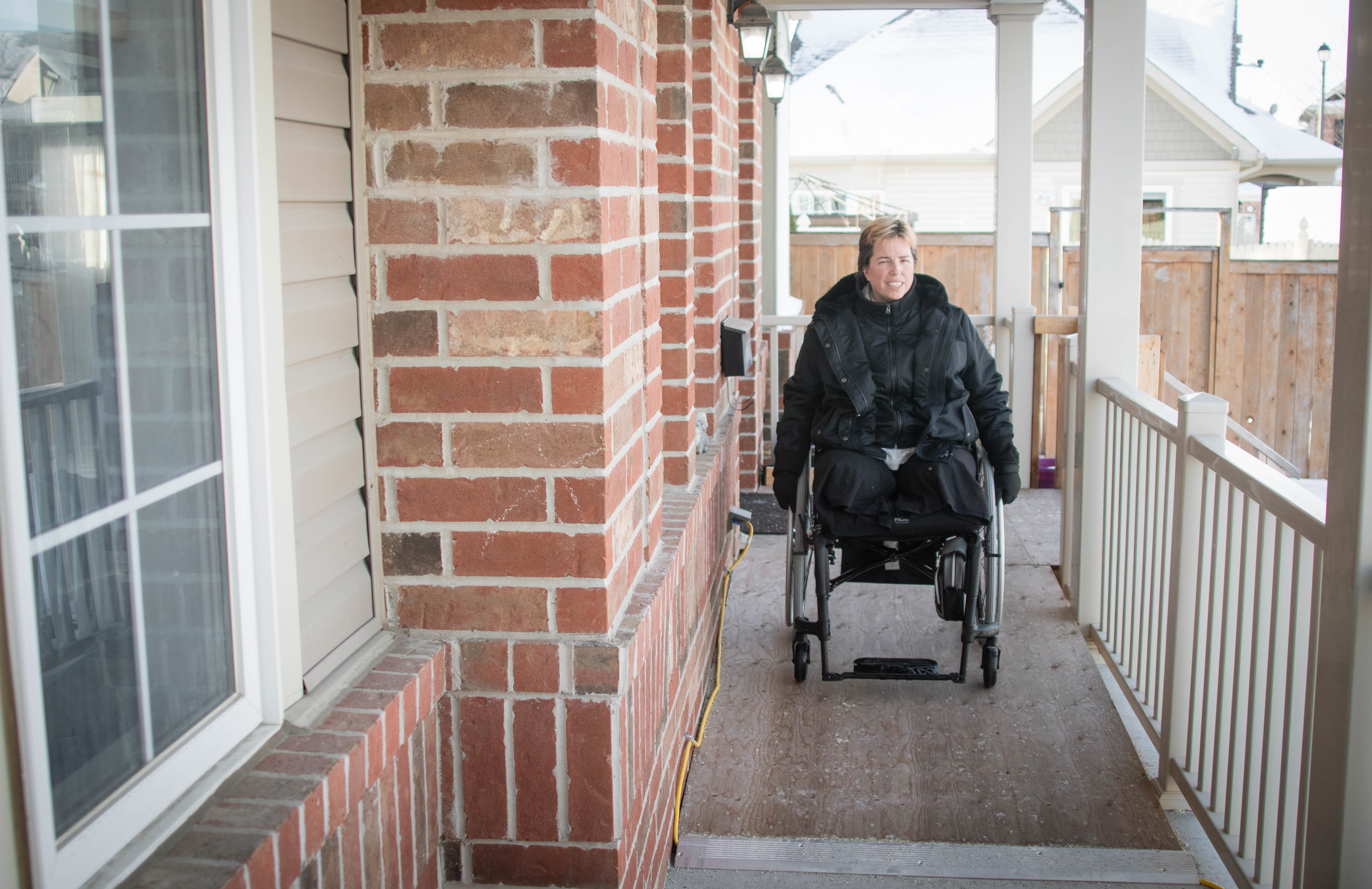 Marcie Stevens wheels herself down a ramp she's had to have installed since losing her legs in the crash. (Trevor Pritchard/CBC)