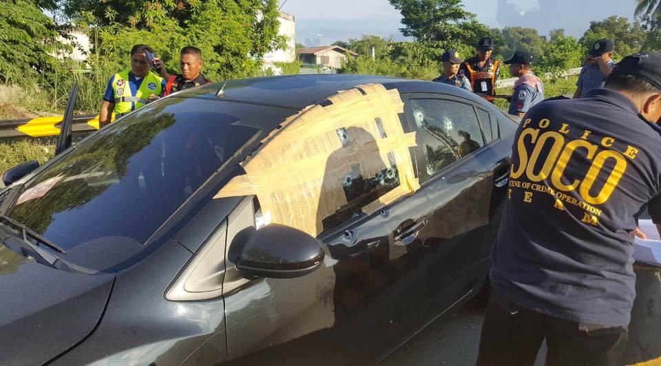 Philippine police examine INC critic Jose Fruto’s bullet-ridden car. (Rappler)