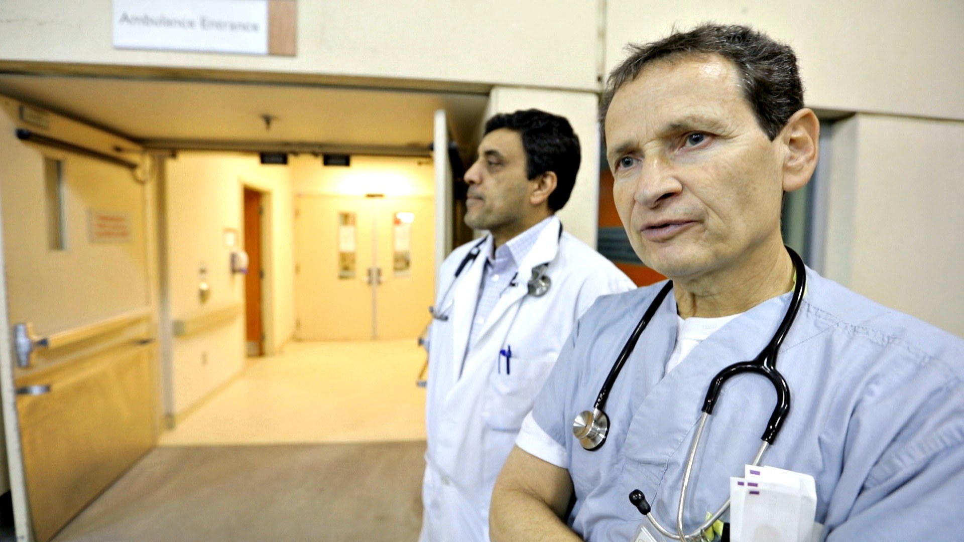 Dr. Naveed Mohammad and Dr. Oscar Karbi gaze out at the ambulance bay. (Paul Borkwood/CBC News)