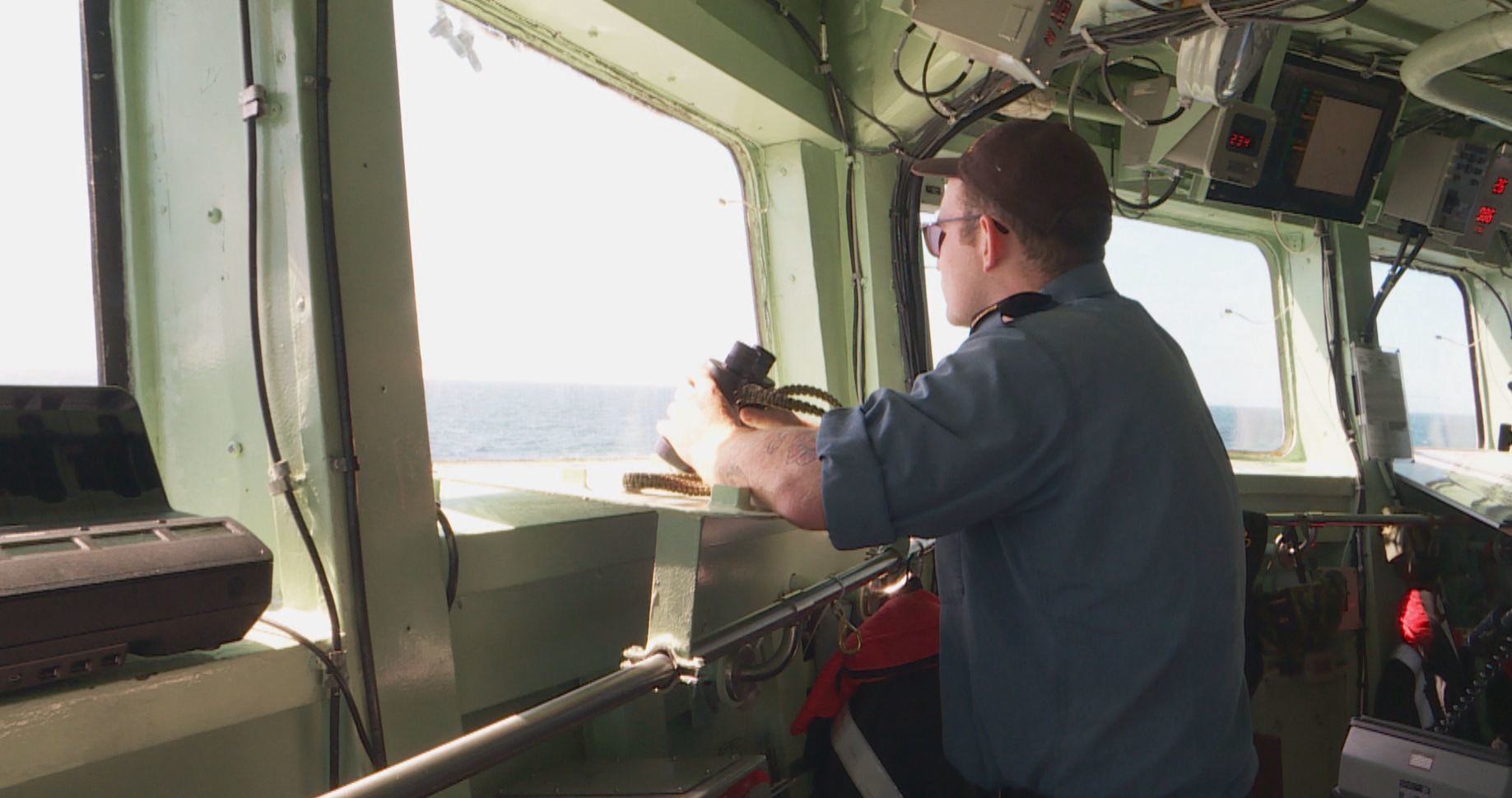Dylan French keeps an eye out for icebergs as the ship heads north. His job as a boatswain rotates him through other jobs, like steering the ship, or launching one of Charlottetown’s small inflatable boats. (Peter Cowan/CBC)