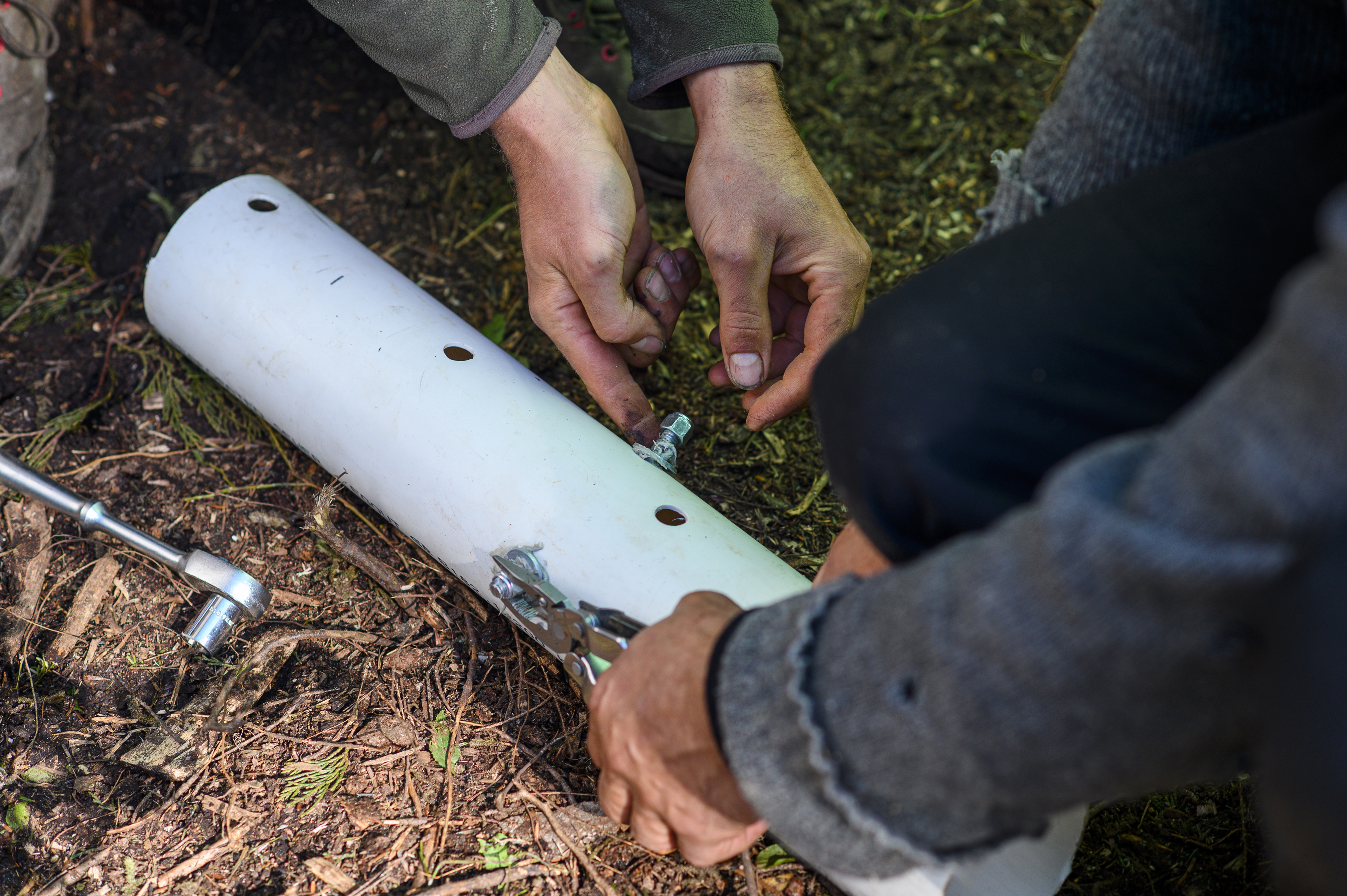 Activists use metal bars and glue to re-enforce PVC piping that will be cemented to the ground to thwart police and make it harder to remove the protesters from the camp. (Kieran Oudshoorn/CBC)