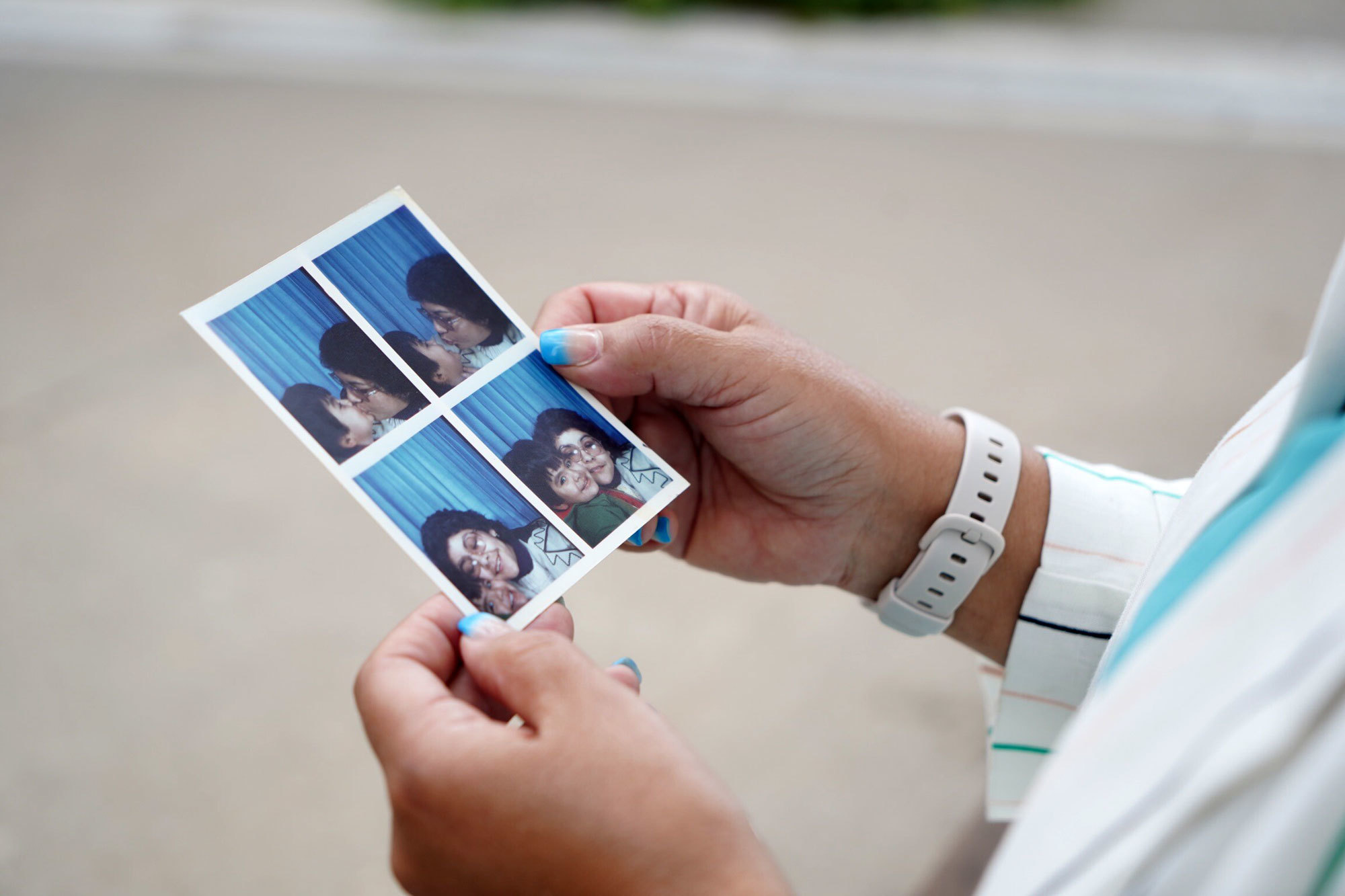 Jiménez holds photos of herself and her son taken shortly after they arrived in Canada at the end of 1983. (Charles Contant/CBC)