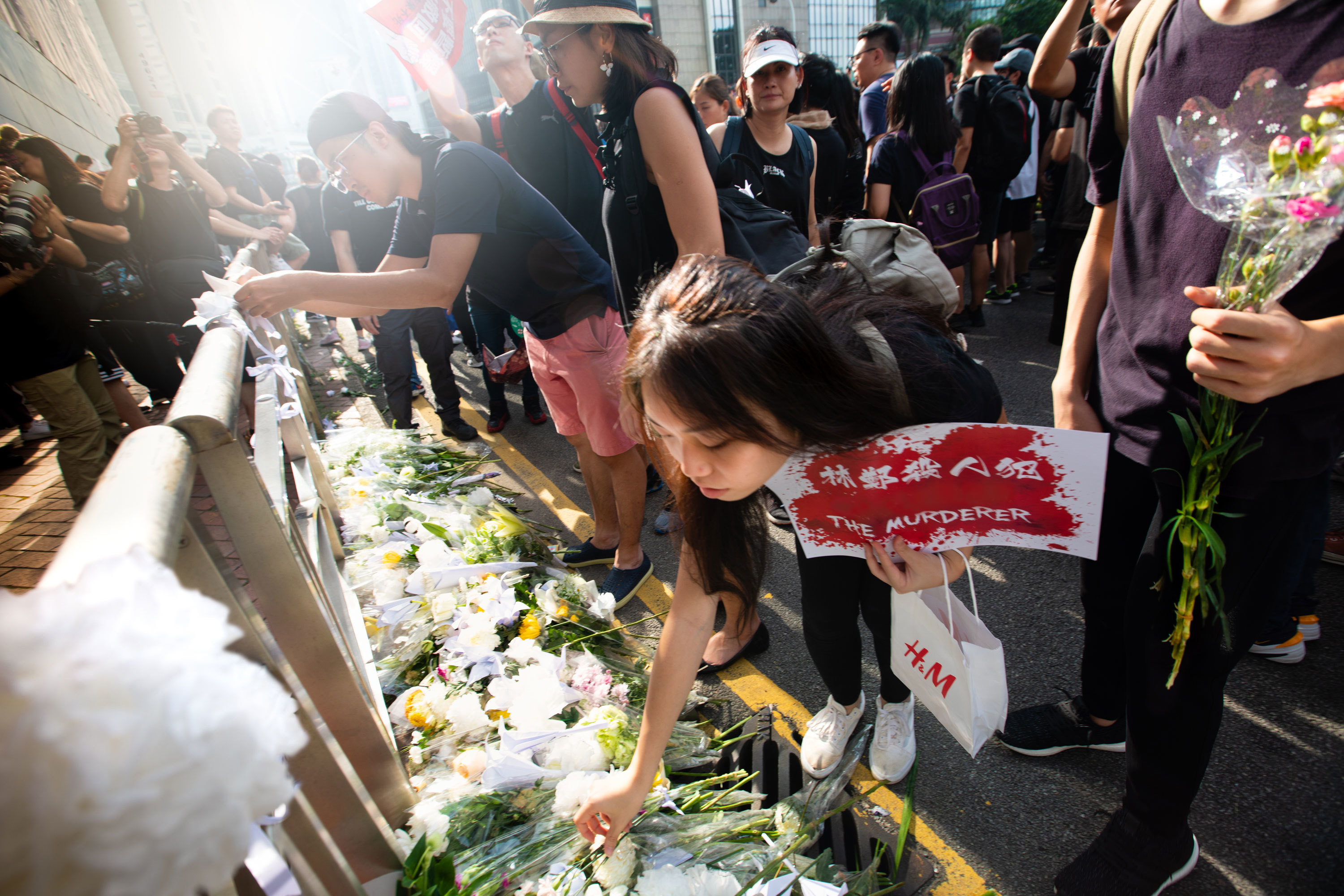 Mourners lay flowers at the memorial of a protester who took their own life. (Saša Petricic/CBC)