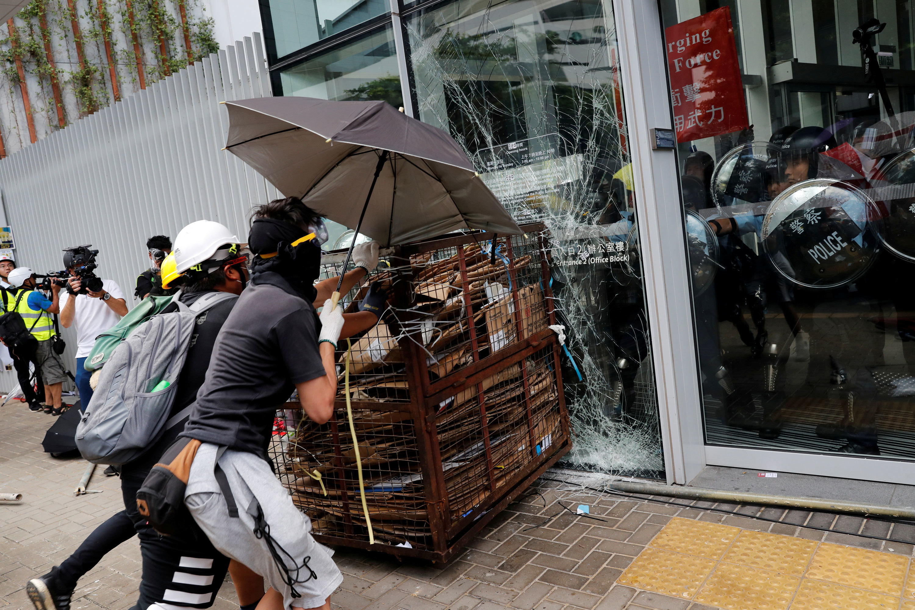 Protesters try to break into the Legislative Council building as riot police look on from inside. (Tyrone Siu/Reuters)