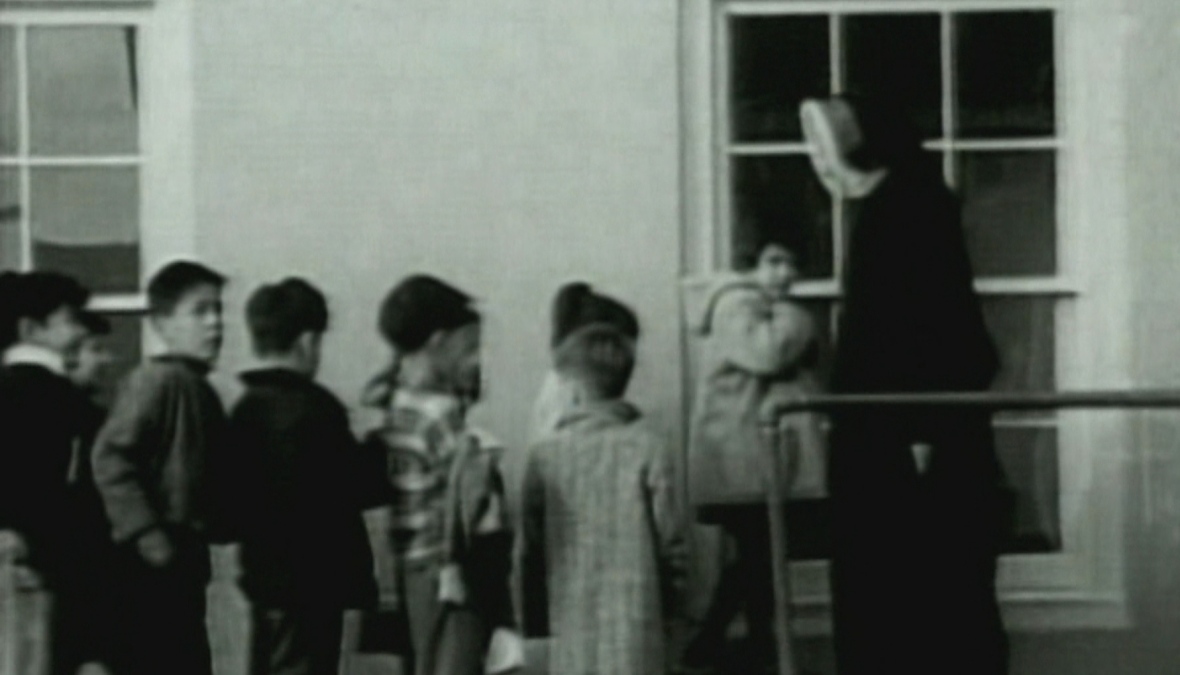 Indigenous children enter a residential school in this undated archival footage. (CBC Archives)