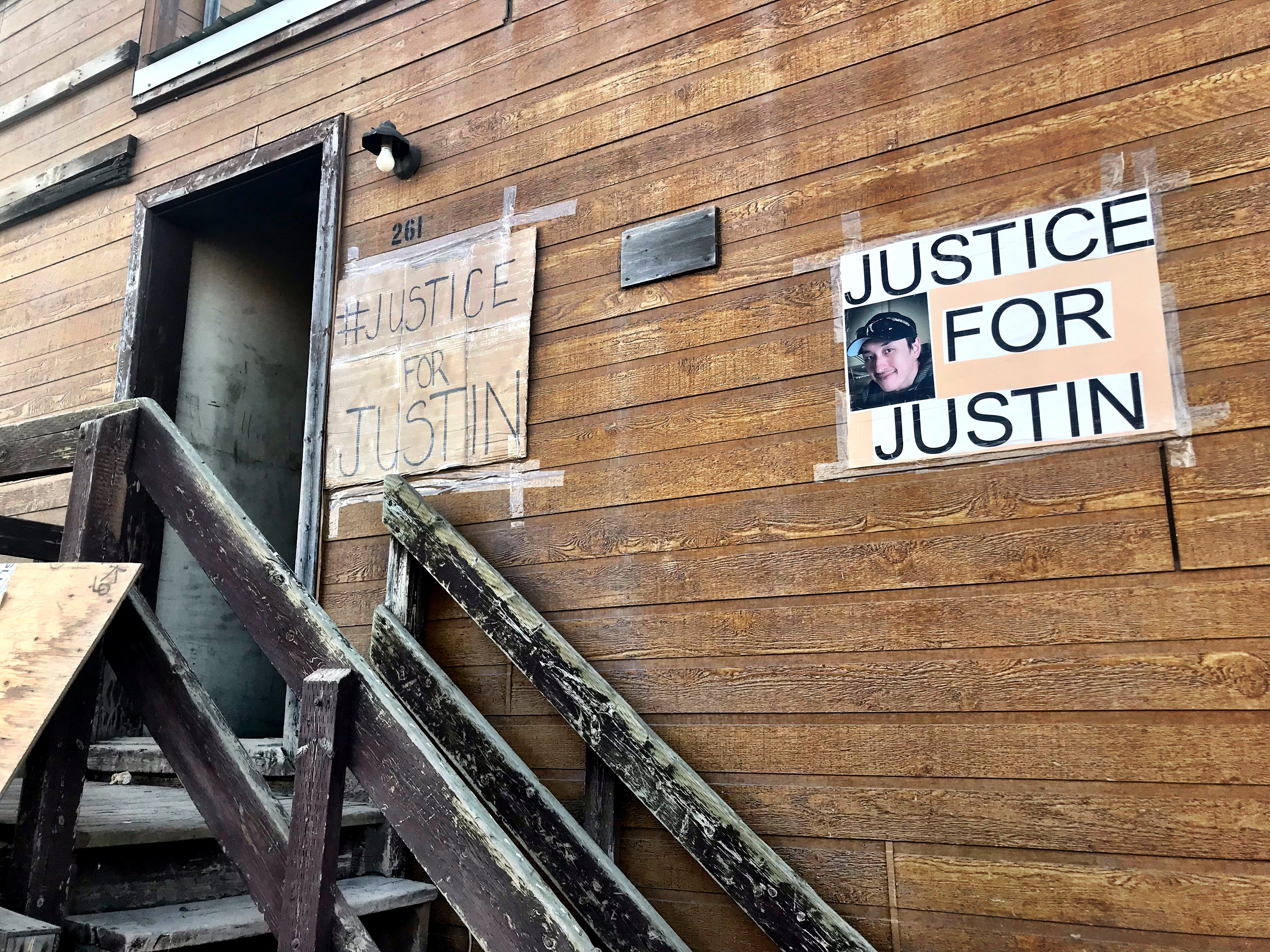 Two signs calling for justice for Justin Pigalak's death hand in the front of Megan Klengenberg's house. Pigalak committed suicide in July. (Hilary Bird/CBC)