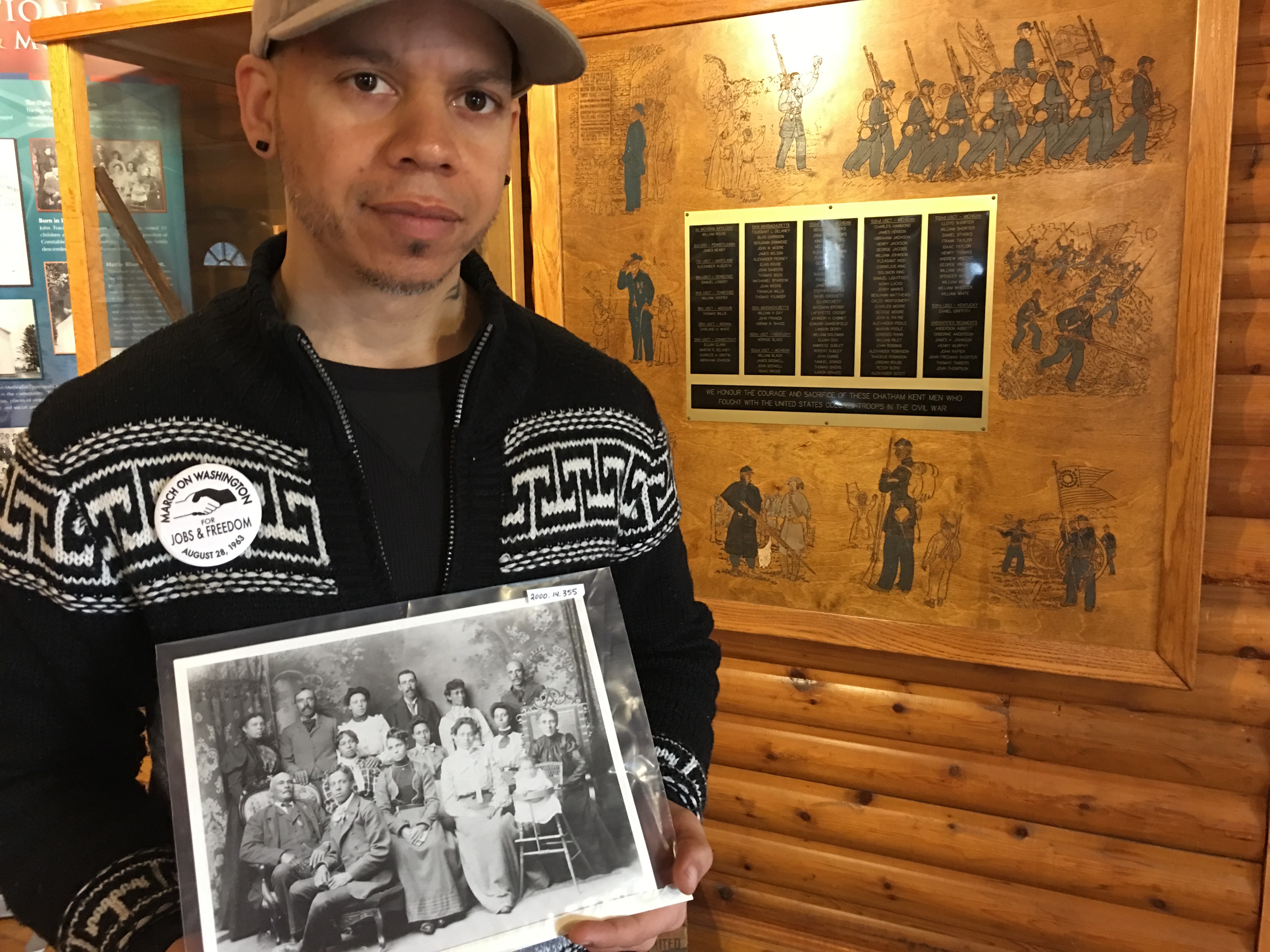 Teajai Travis holds a photo of his family which settled in Buxton, Ont. in the 1800s.