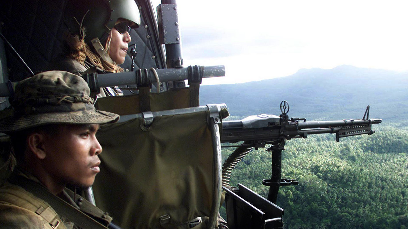 Filipino soldiers provide air cover for troops pursuing Abu Sayyaf members in dense jungle terrain. (Erik de Castro/Reuters)